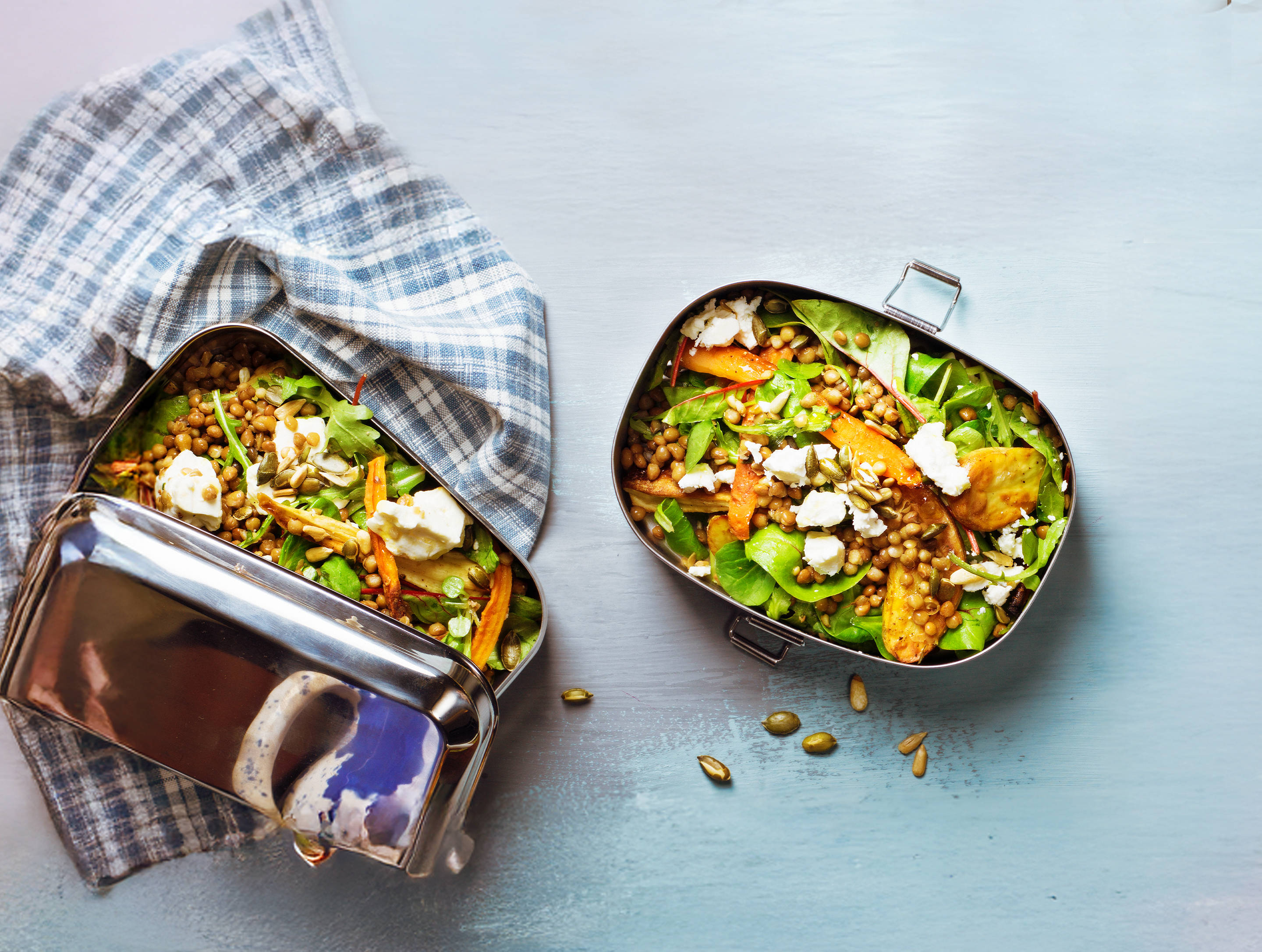 Gesunder Linsensalat in einer Lunchbox aus Edelstahl.