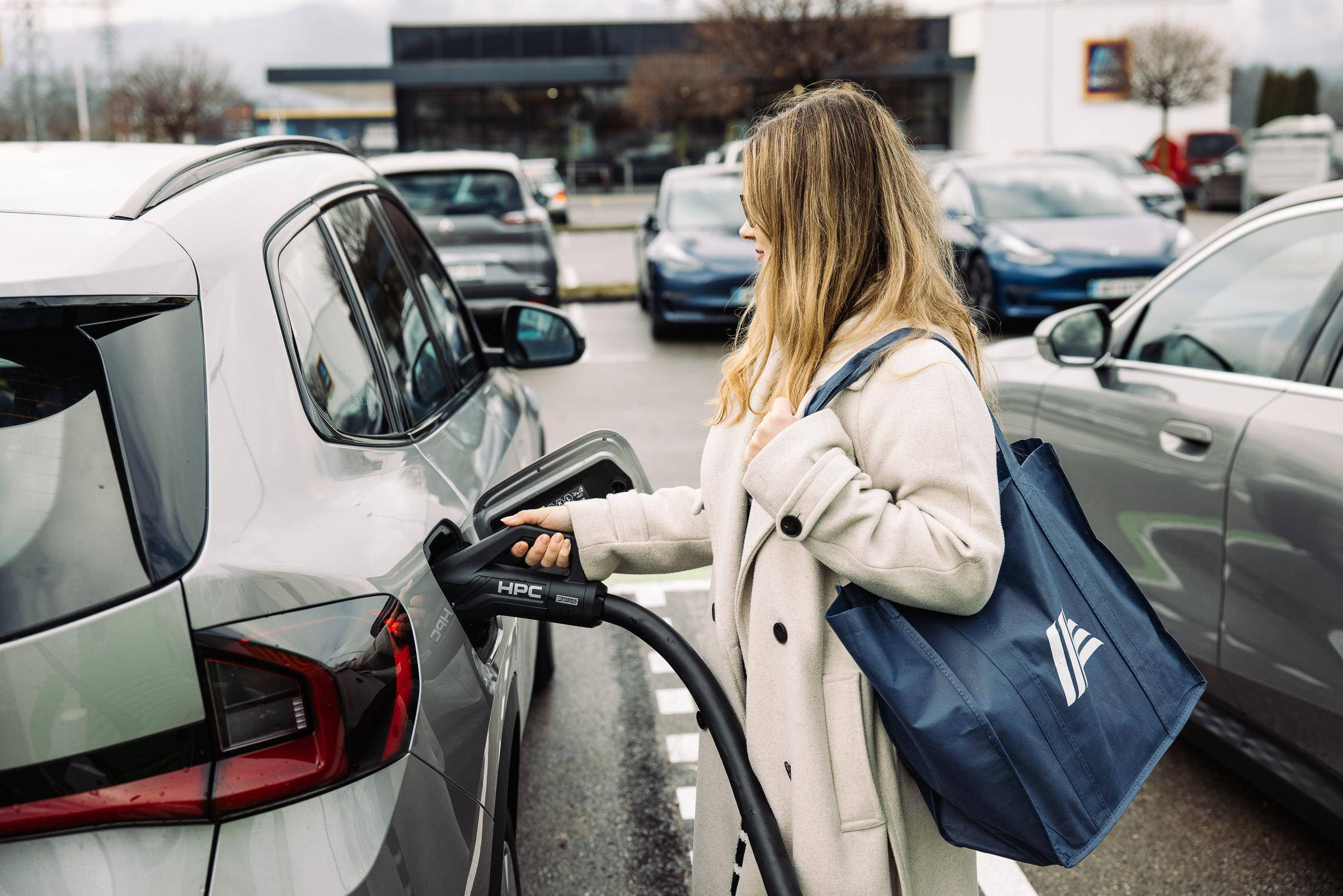 Ženska, ki polni električni avto