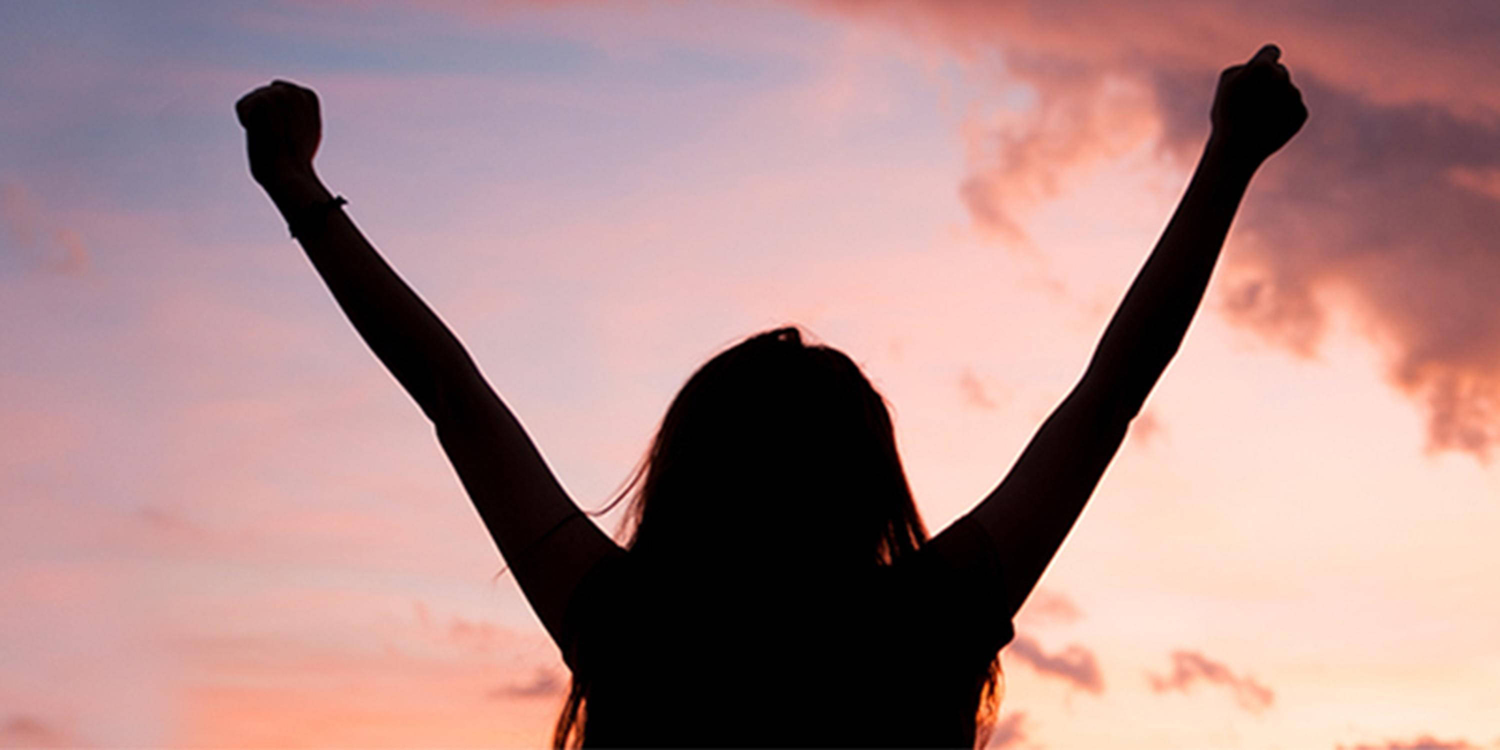 Silhouette einer Frau, im Hintergrund rosa gefärbter Himmel mit einer Wolke