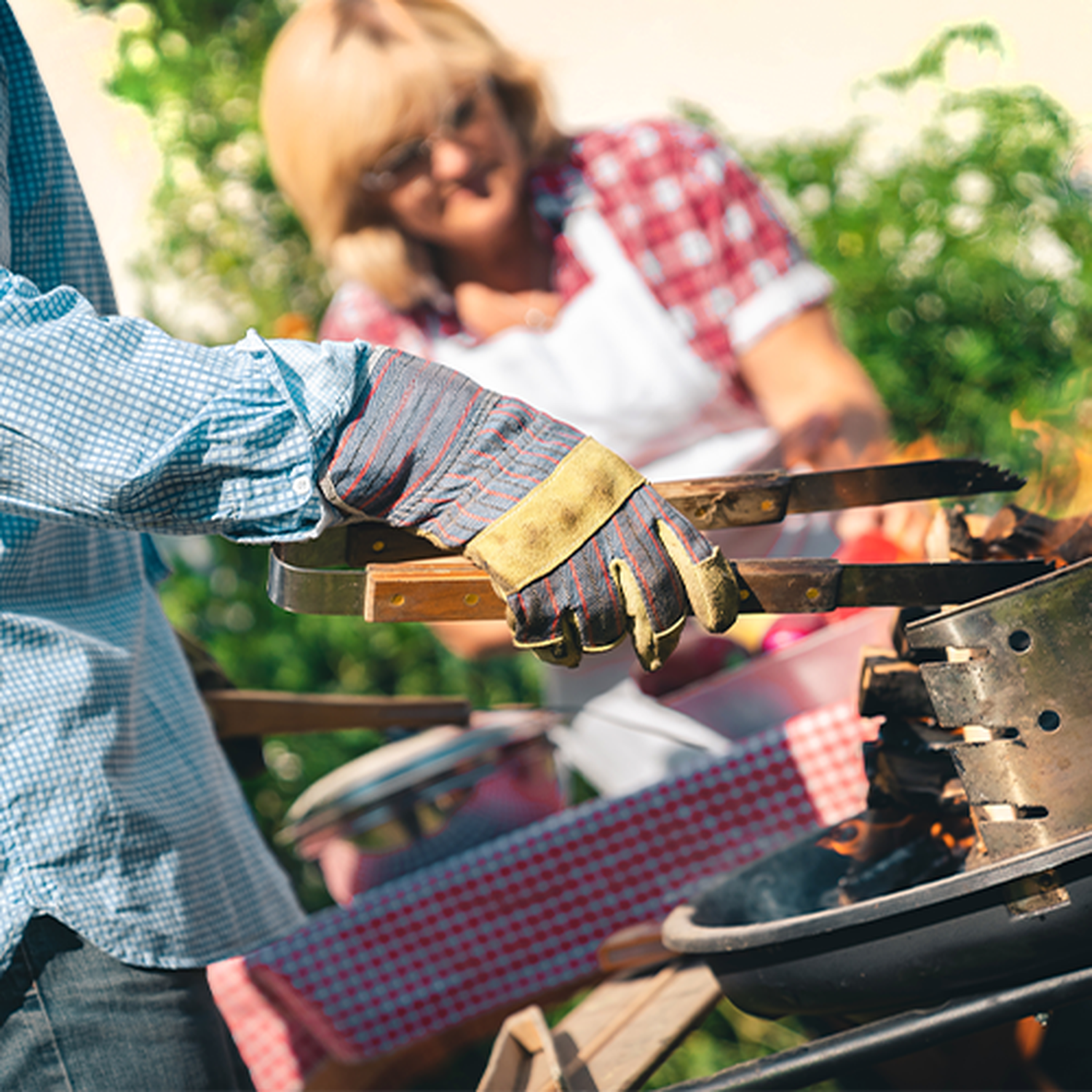 Eine Person grillt mit Handschuhen.
