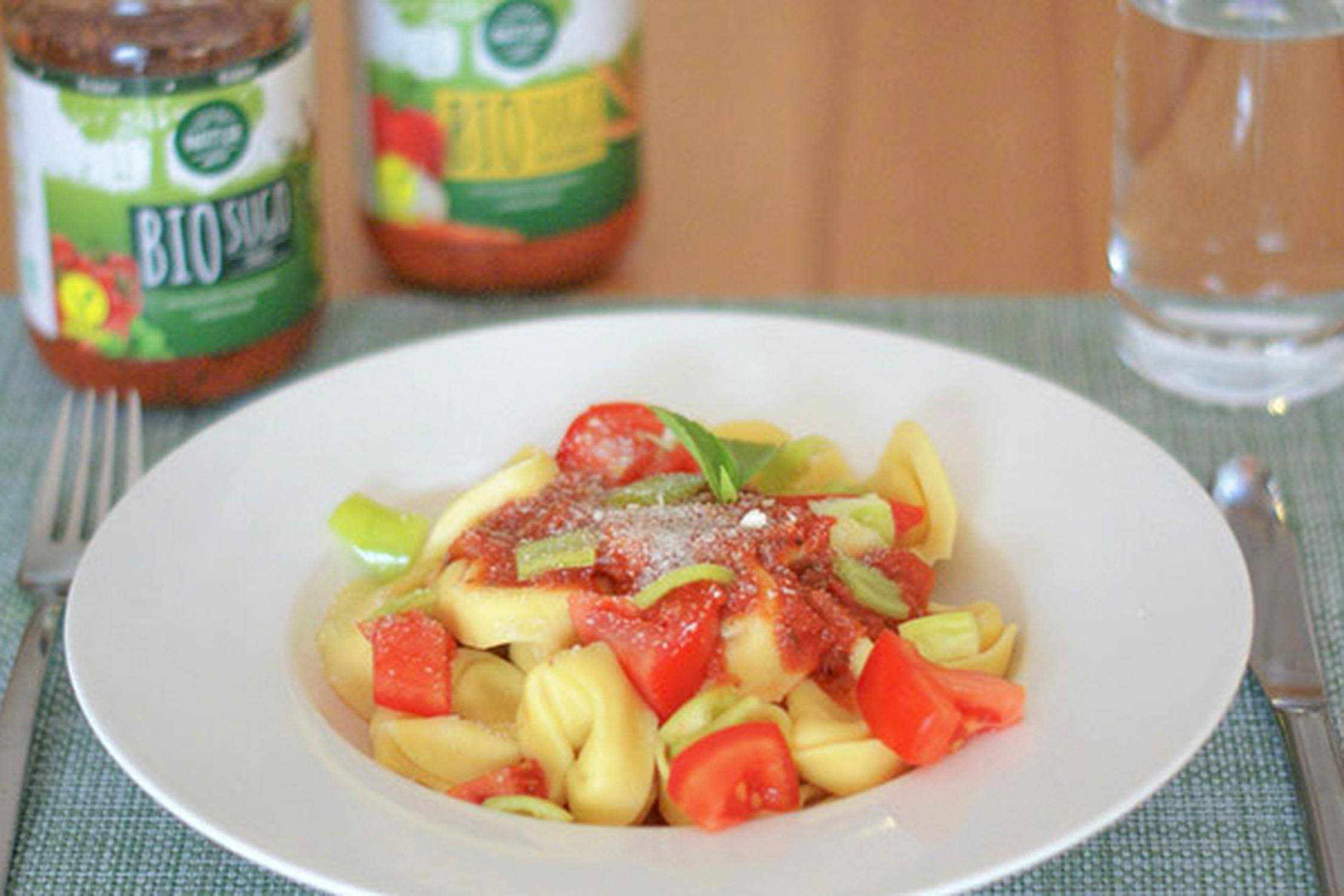 Teller mit Tortellini und Tomaten.