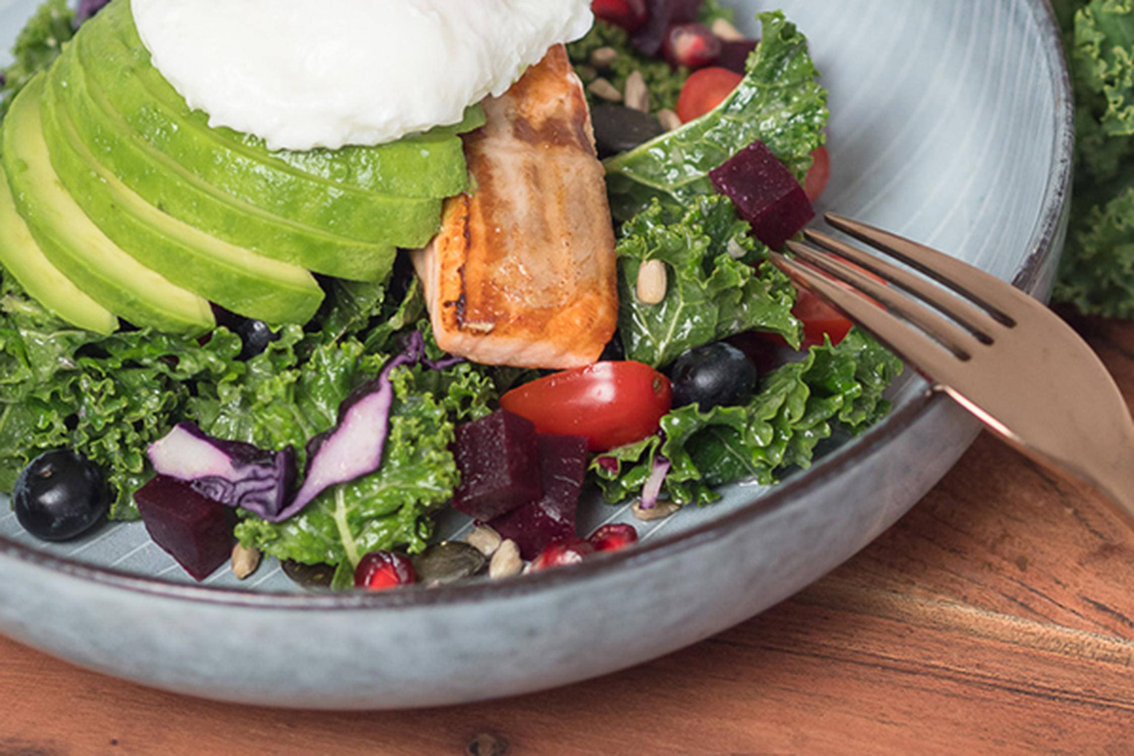 Schüssel mit Avokado, Lachs, Salat und Käse