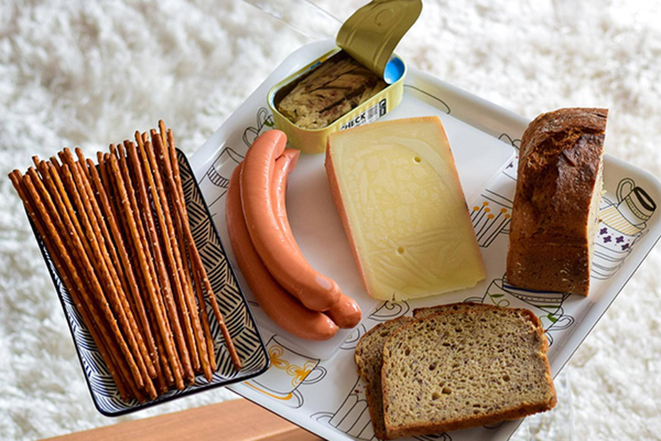 Schale mit Soletti und Tablett mit drei Frankfurtern, zwei Brotscheiben, Käse und offener Fischkonerve