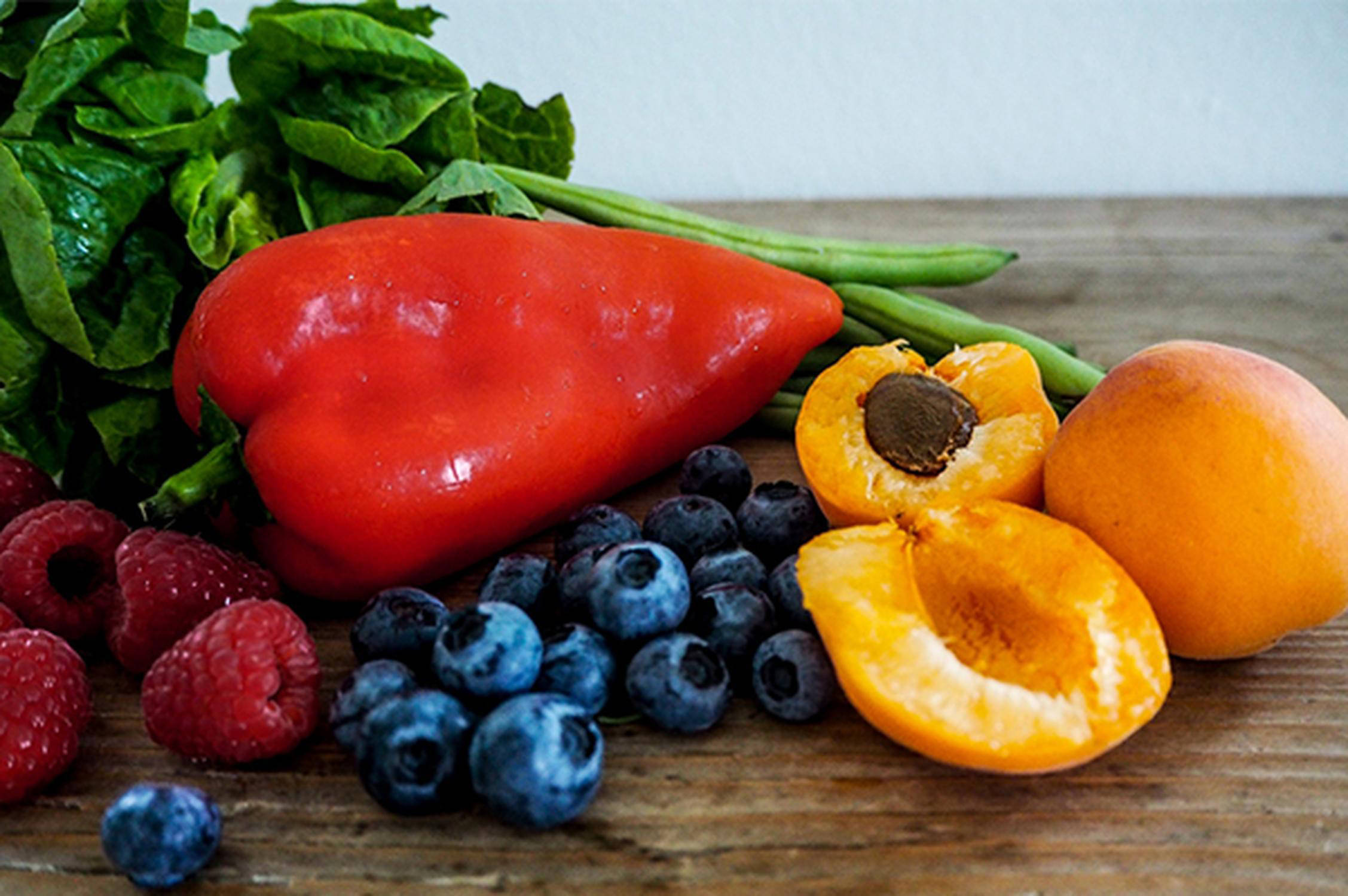 Paprika, Himbeeren, Heidelbeeren und Marillen liegen nebeneinander