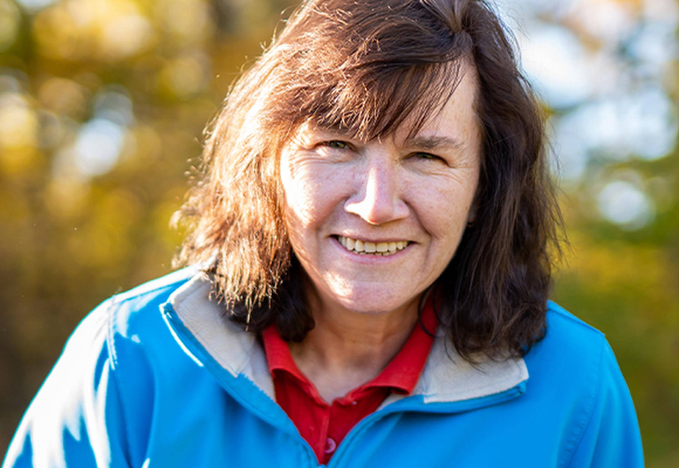 Lächelnde Frau mit blauer Jacke.