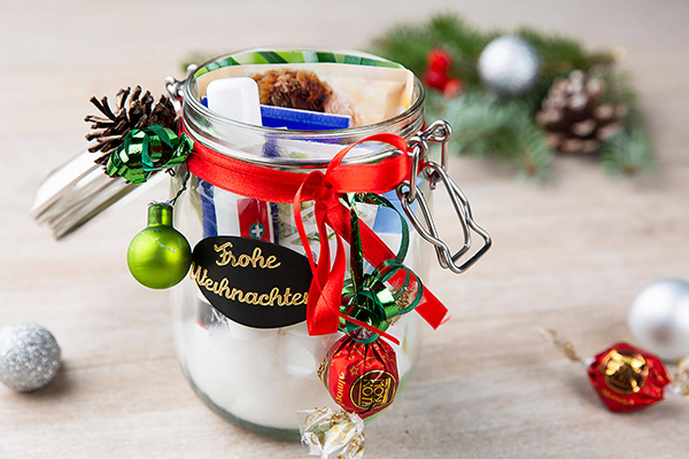 weihnachtlich dekoriertes Einmachglas mit Süßigkeiten gefüllt