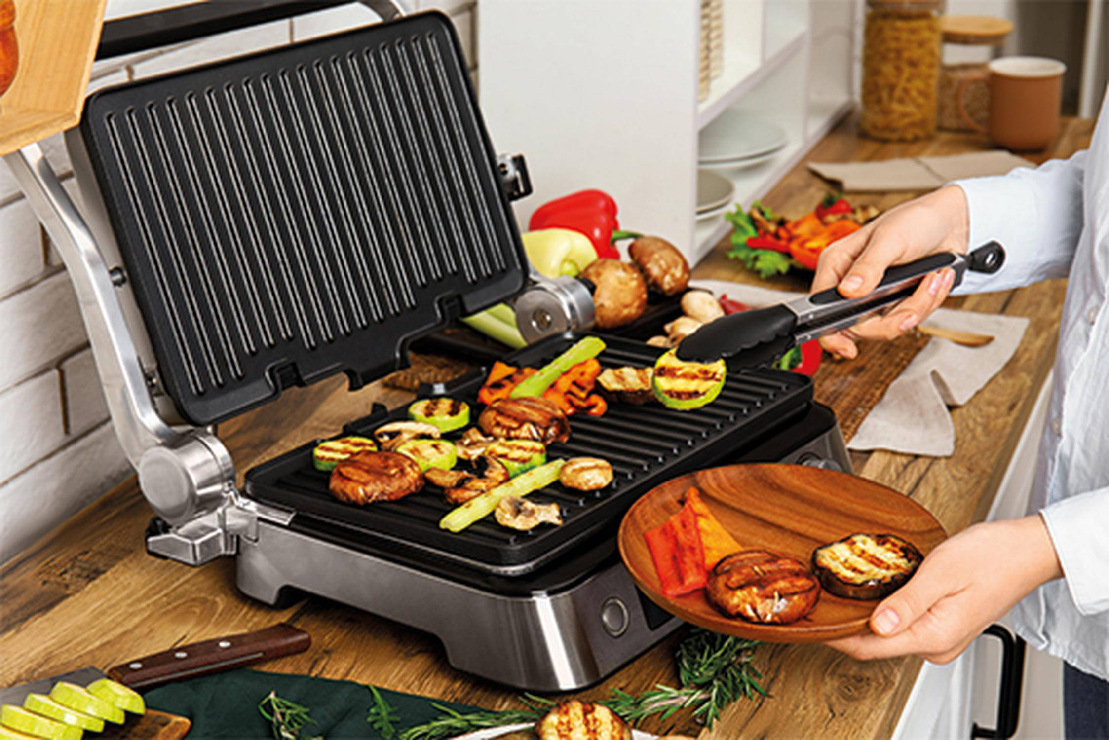 Auf dem Bild sieht man wie verschiedene Grillartikel vom Elektrogrill entfernt werden.