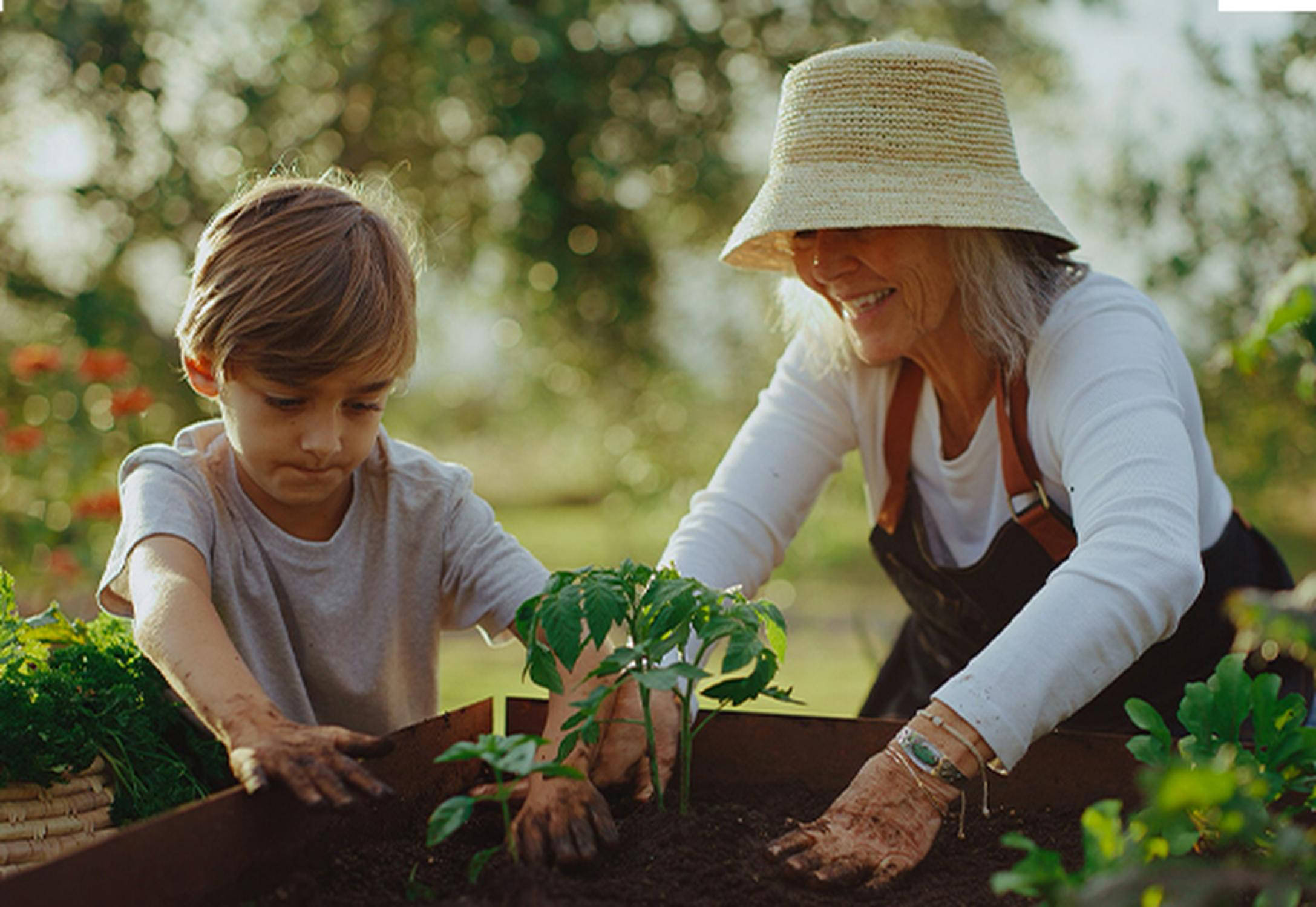 Großmutter mit Sohn bei Hochbeet