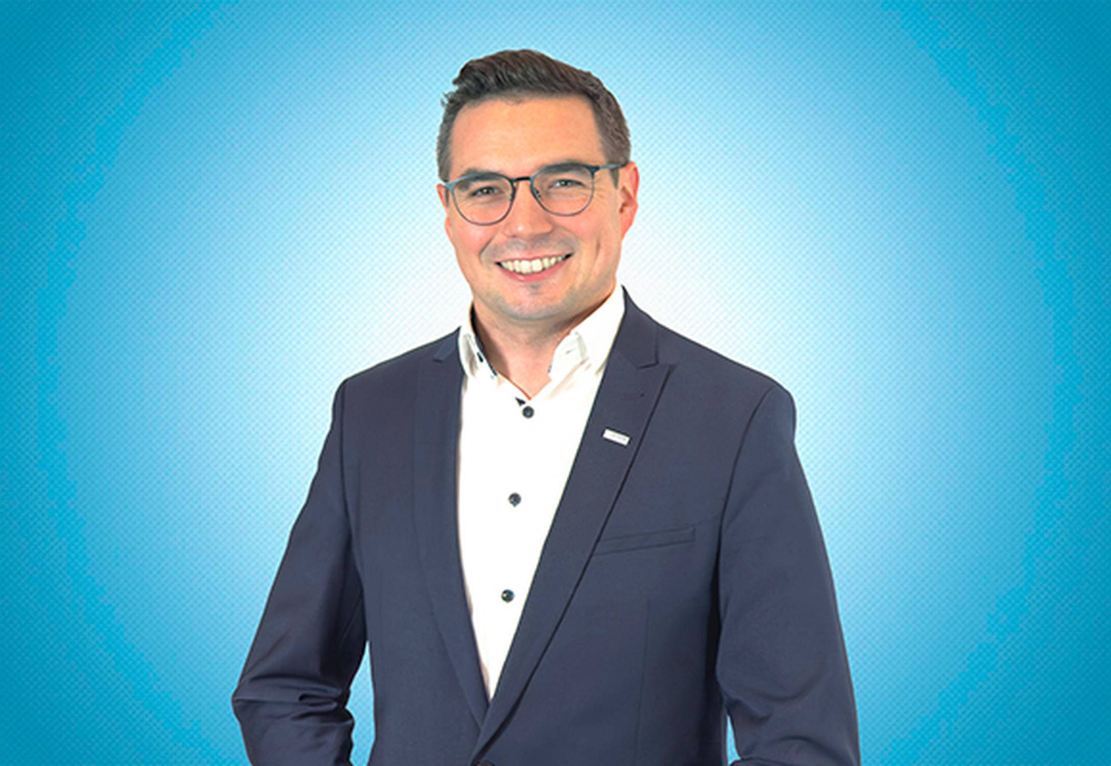 Mann mit Anzug und Brille.