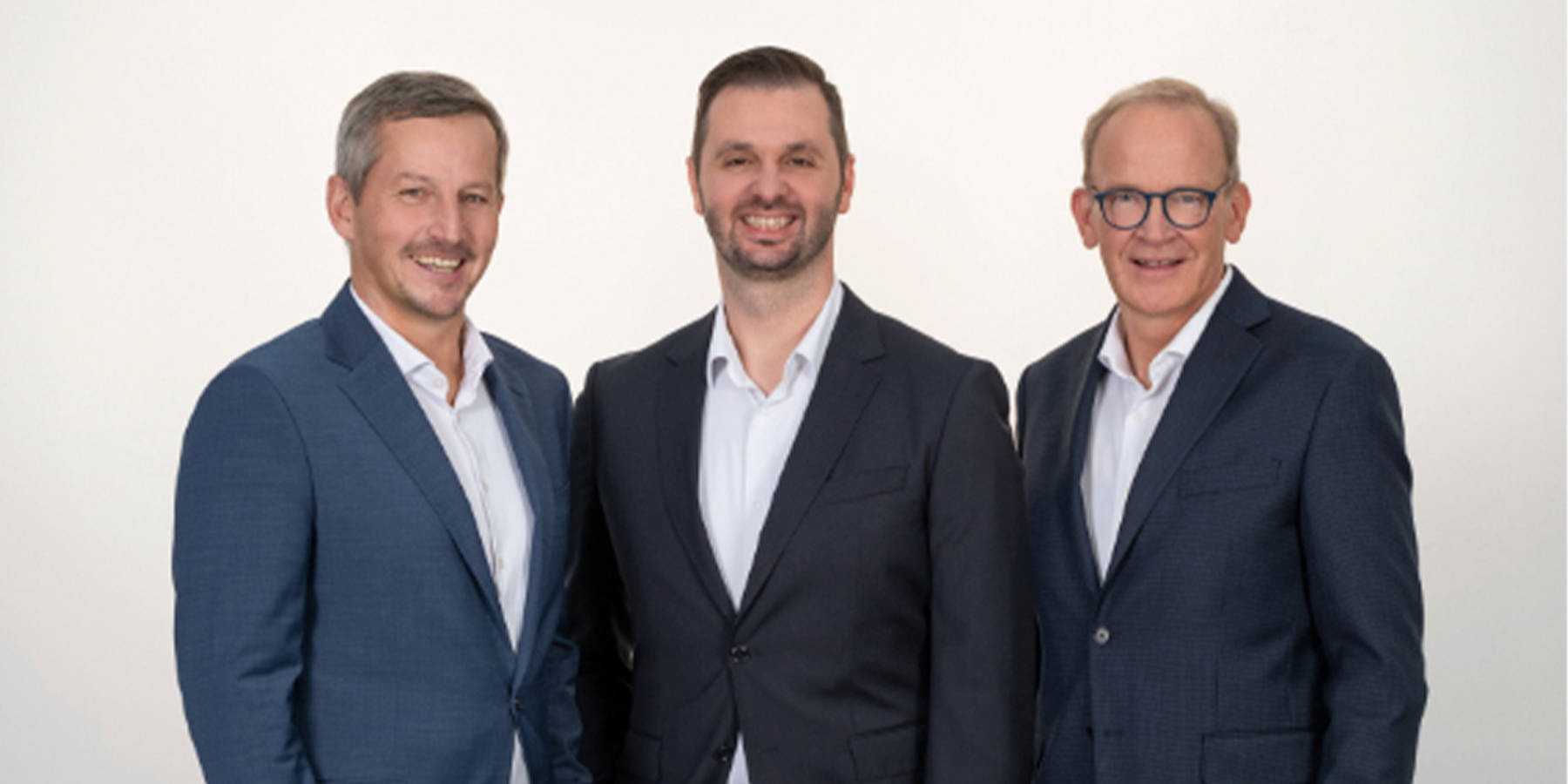 Zwei Herren halten gemeinsam einen großen Korb voll Brot und Gebäck