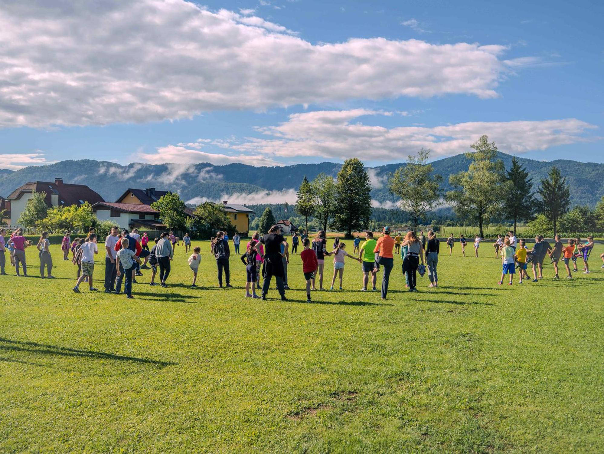 Otroci se igrajo na zelenem travniku.