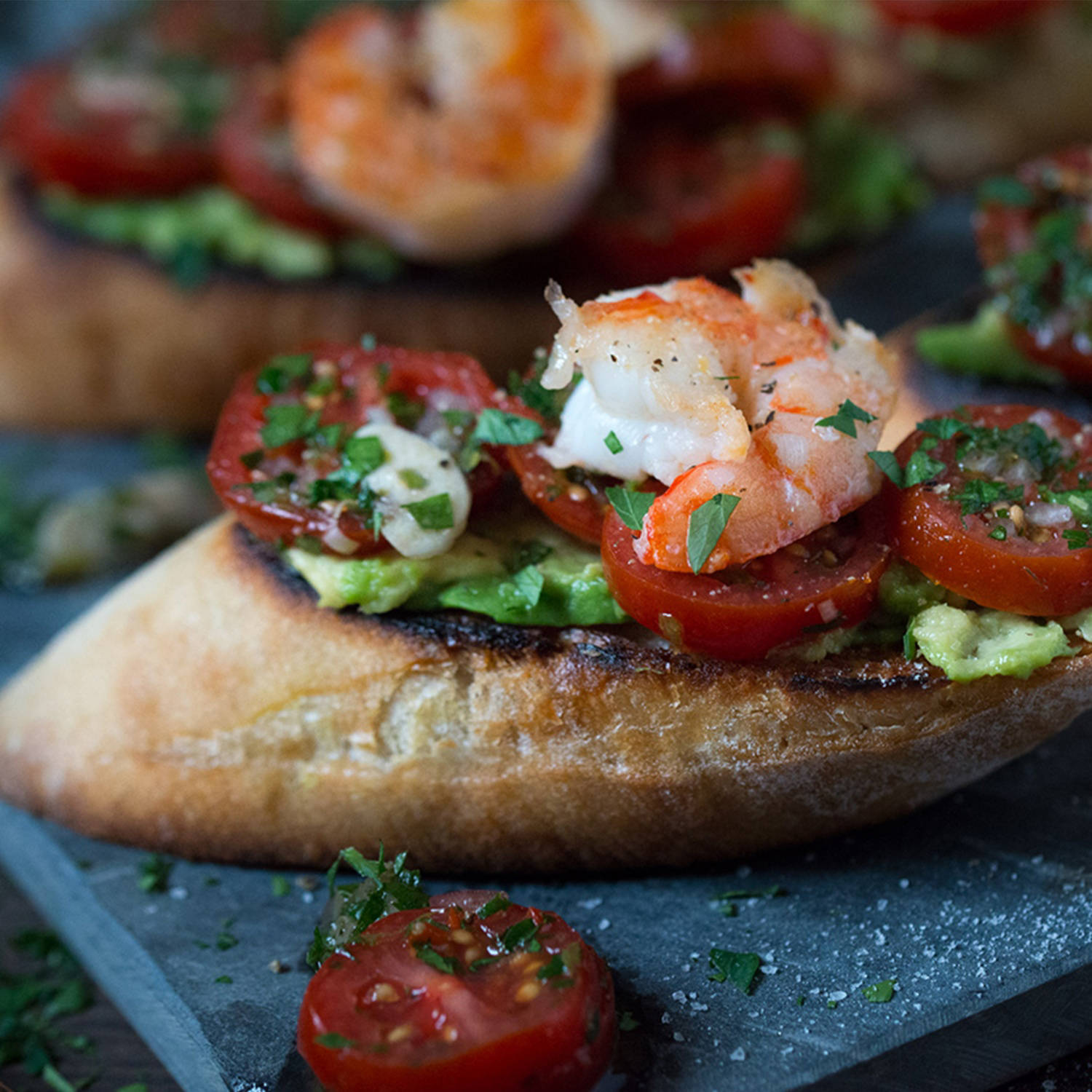Serviervorschlag: Bruschetta mit Kirschtomaten-Avocado-Topping und Garnelen