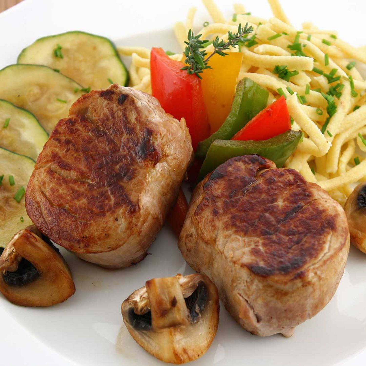 Serviervorschlag: Kräuter-Käsespätzle mit gebratenem Schweinefilet und Walnüssen