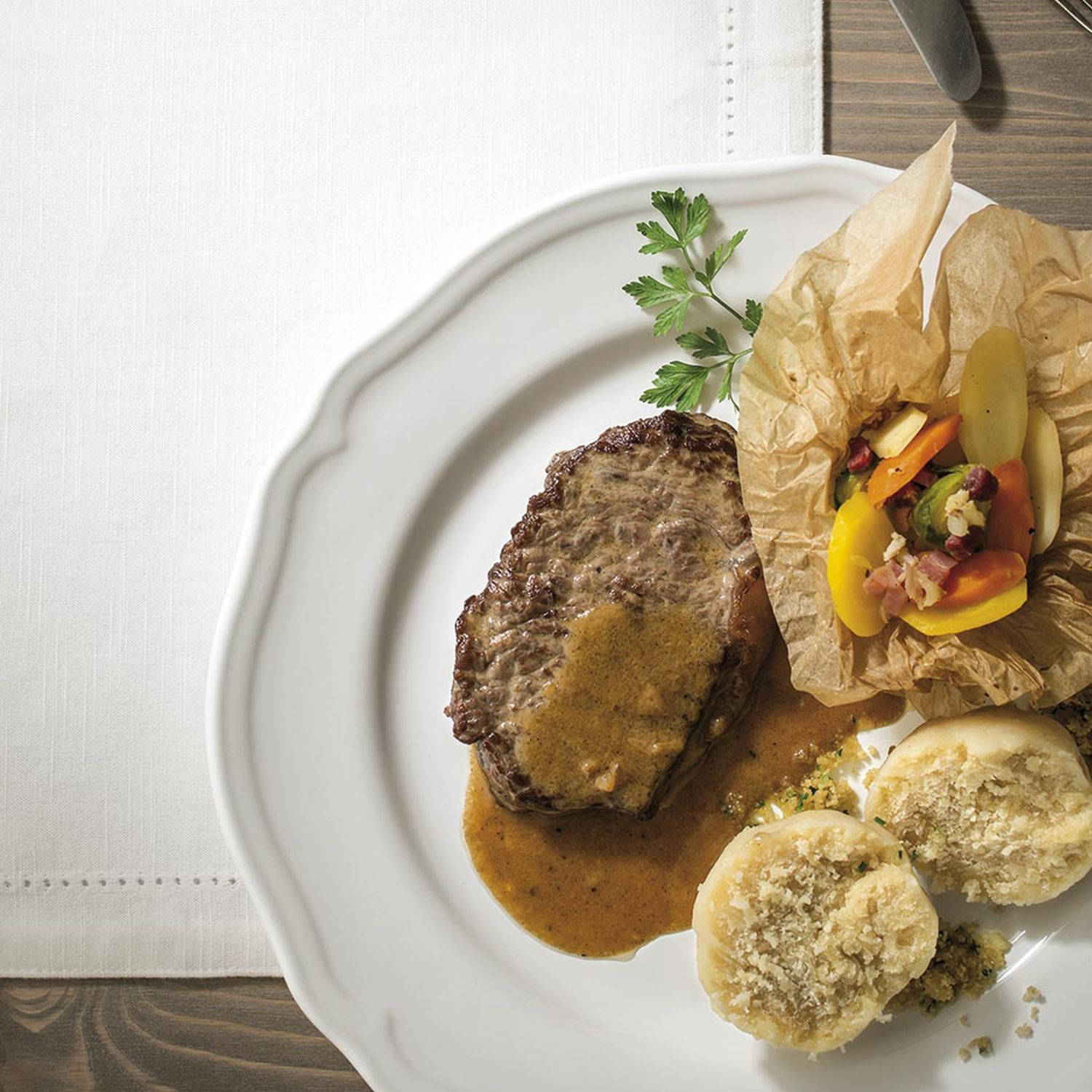 Serviervorschlag: Vanillerostbraten mit Mehlknödeln und Gemüse im Pergament