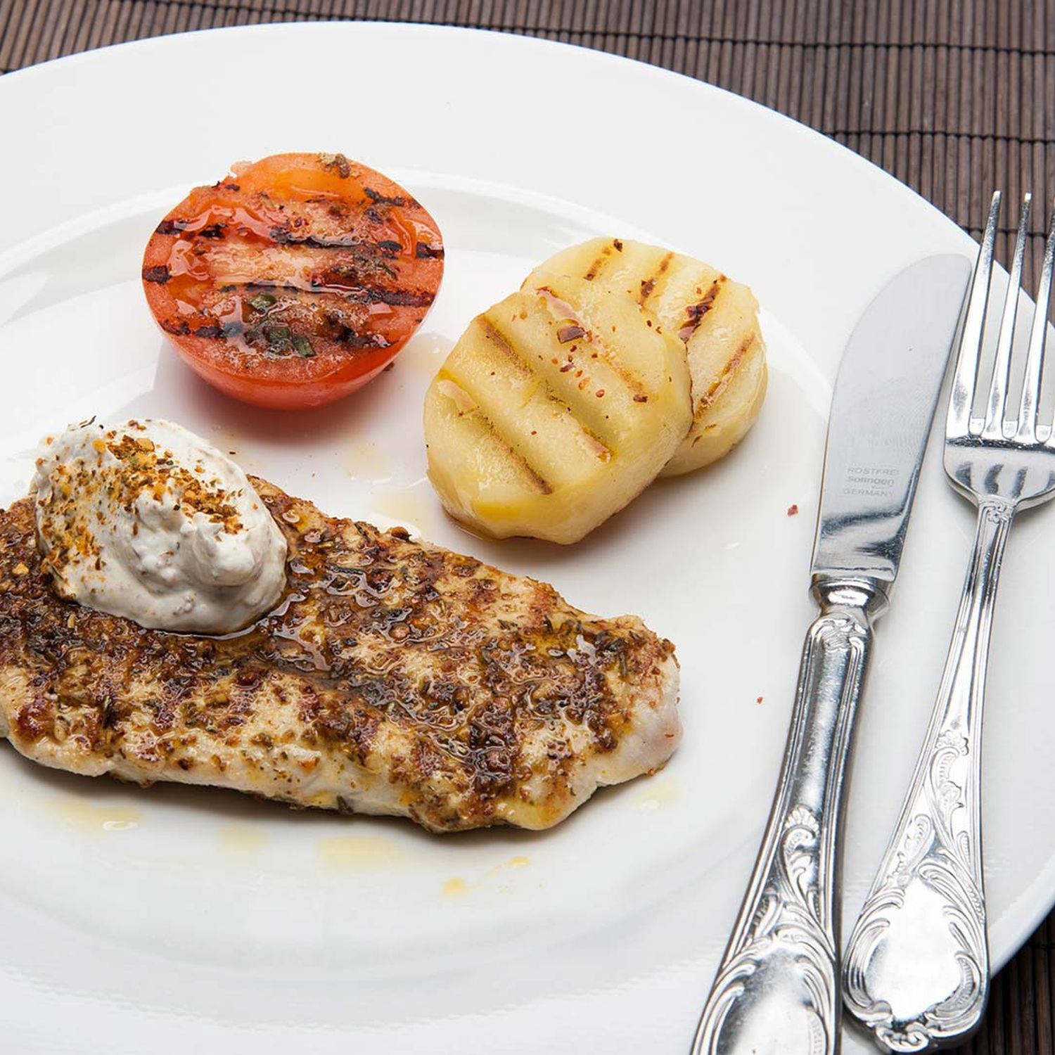 Serviervorschlag: Mariniertes Schweinsschnitzel mit Grilltomate und Gewürzjoghurt