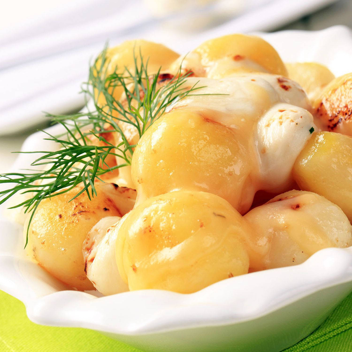Serviervorschlag: Würzige Minikartoffeln mit Käse überschmolzen