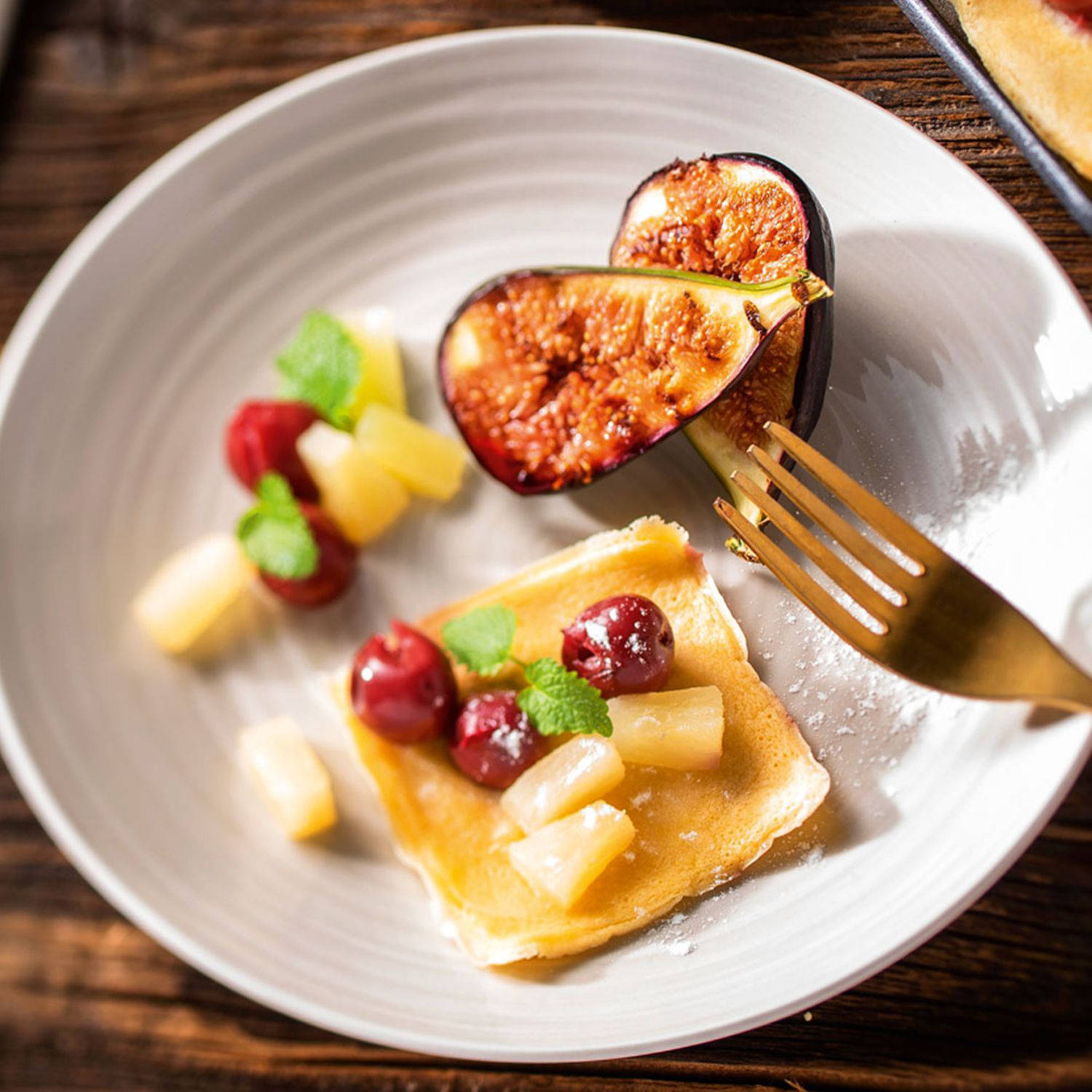 Serviervorschlag: Raclette-Palatschinken-Pfännchen, mit Weichseln und Ananasstückchen