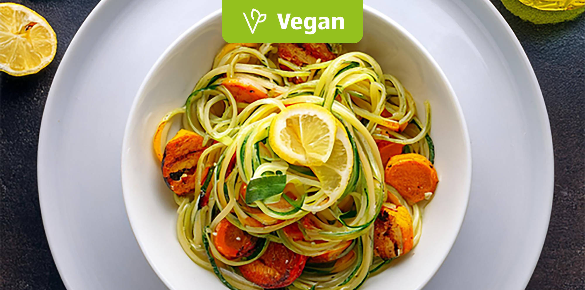 Vegane Zucchini-Nudeln mit Zitronenscheiben.