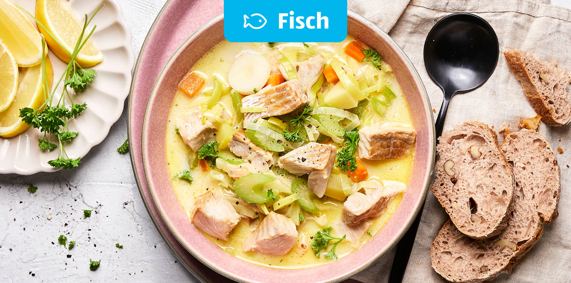 Cremiger Fischeintopf mit Gemüse und Brot.