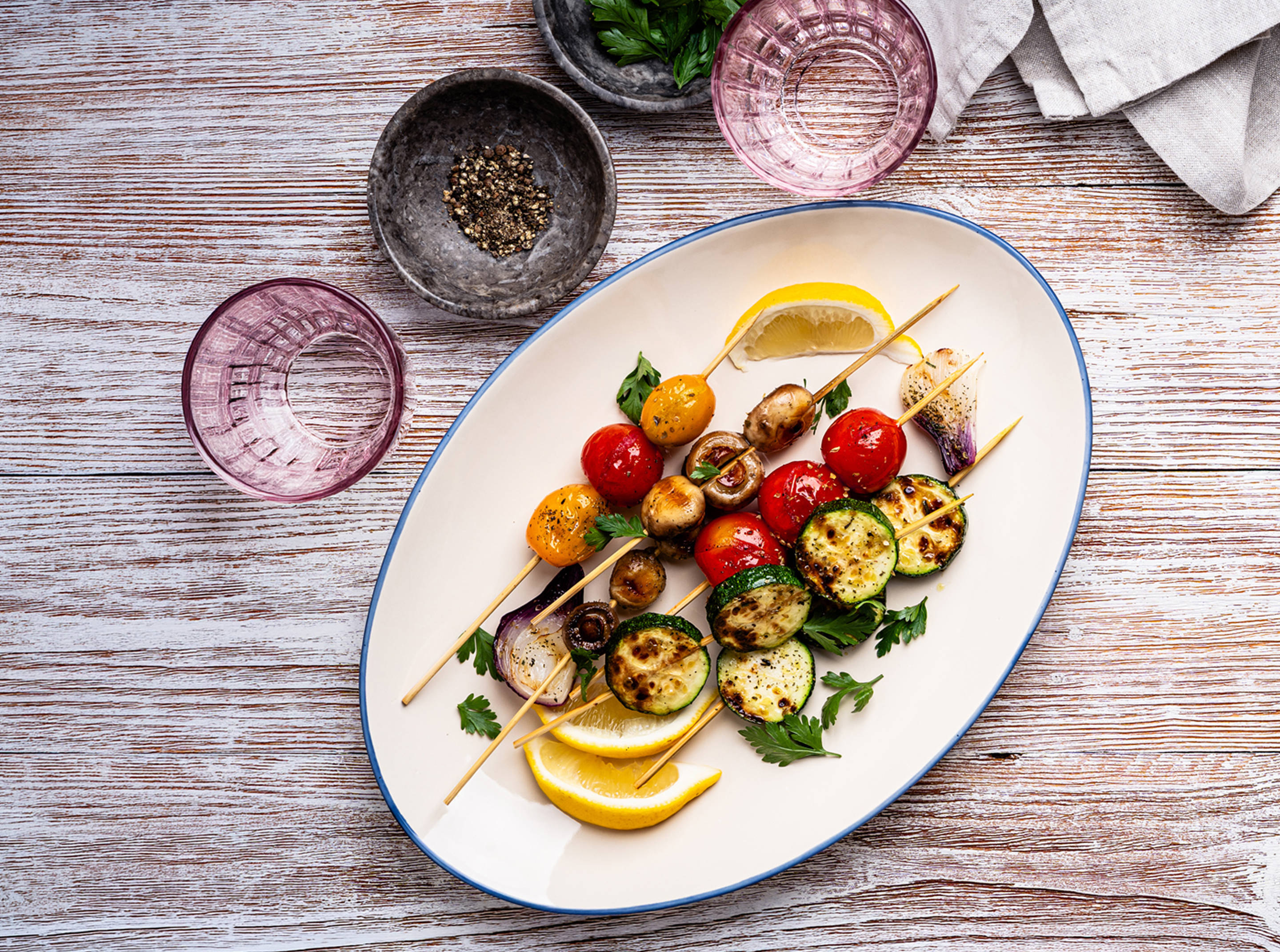 Gemüse-Grillspieß mit Zitrone auf einem weißen Teller.