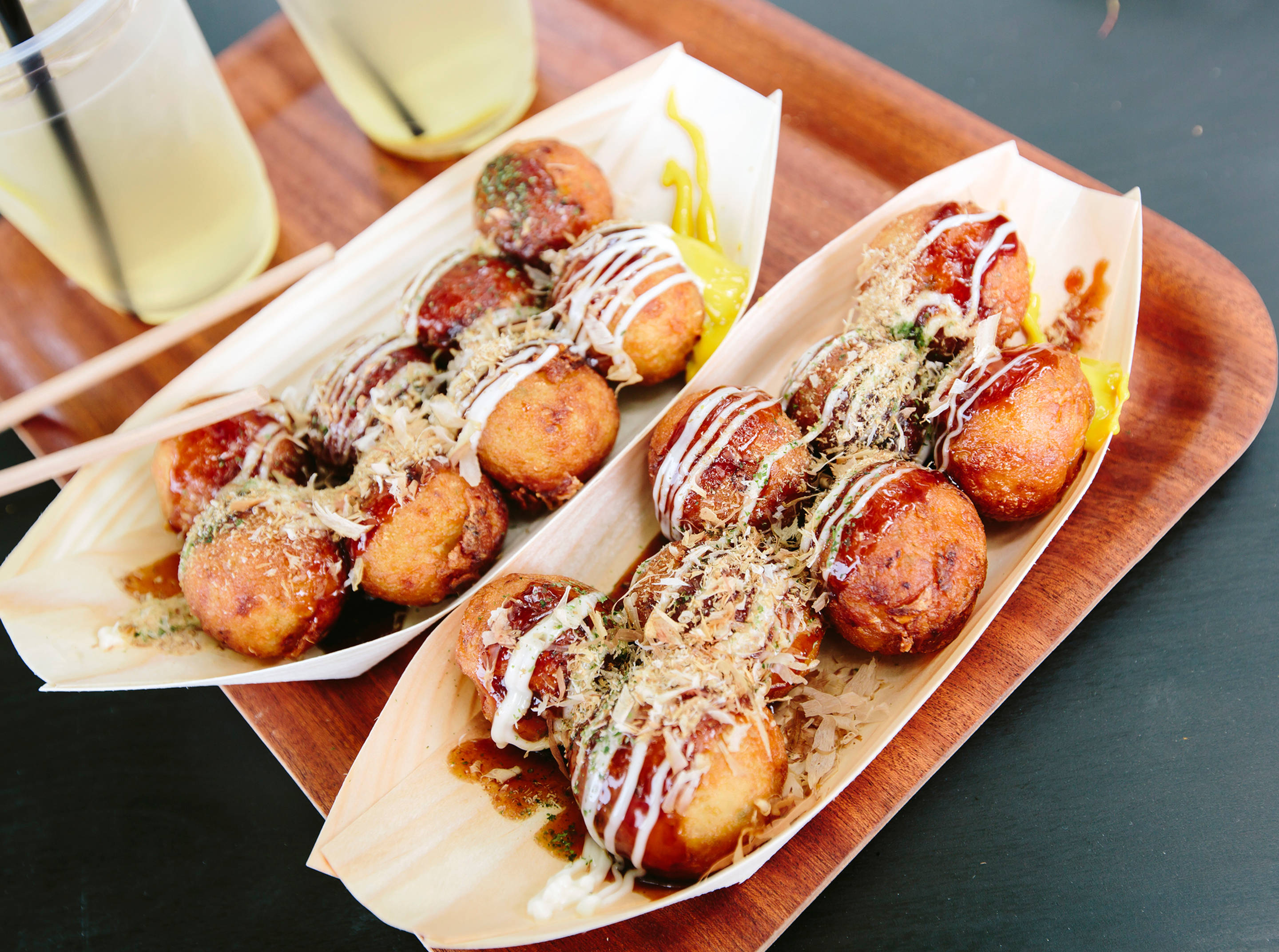 Japanische Takoyaki-Bällchen mit Sauce und Getränken.