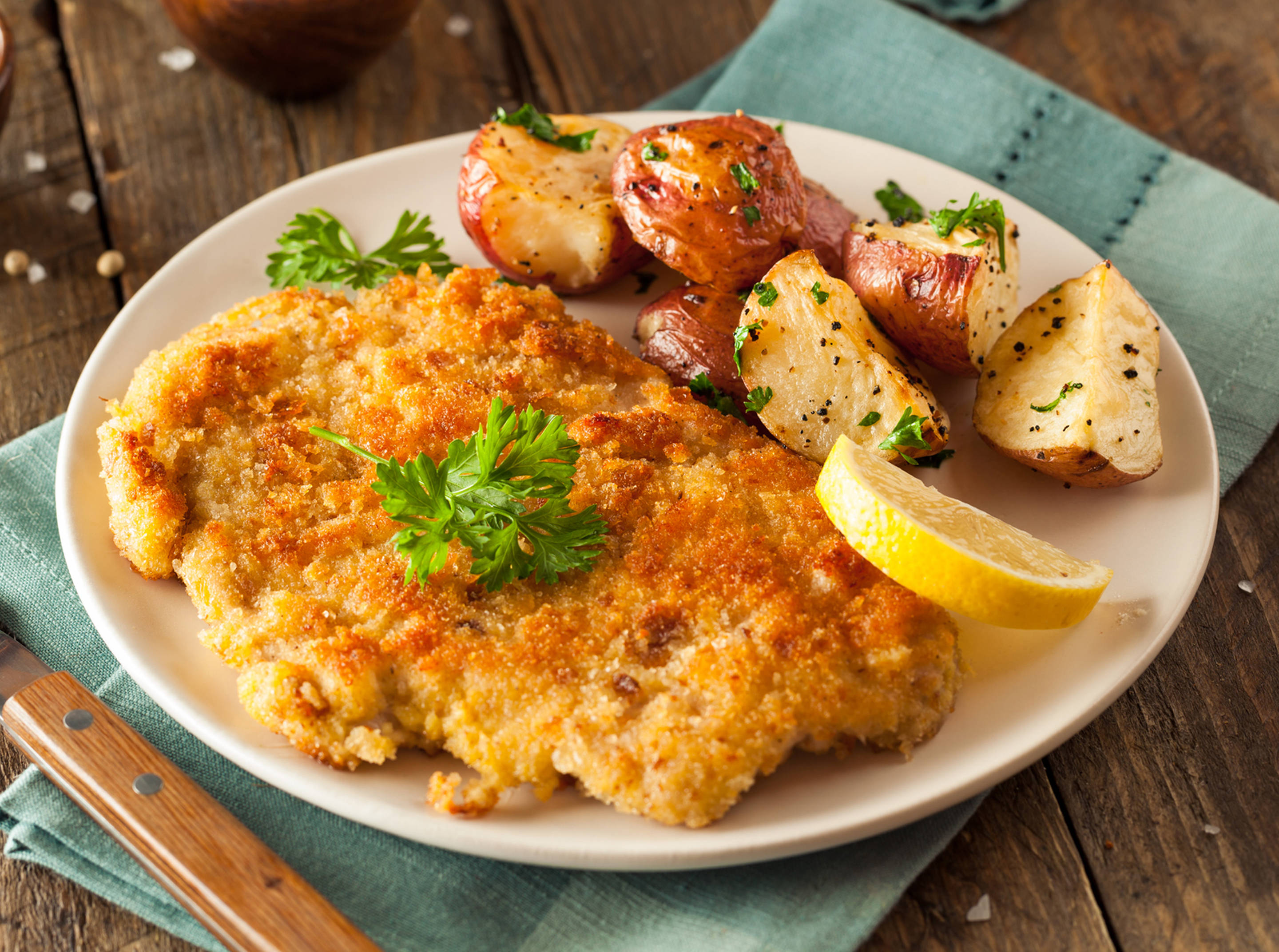 Knusprig paniertes Schnitzel mit Röstkartoffeln.
