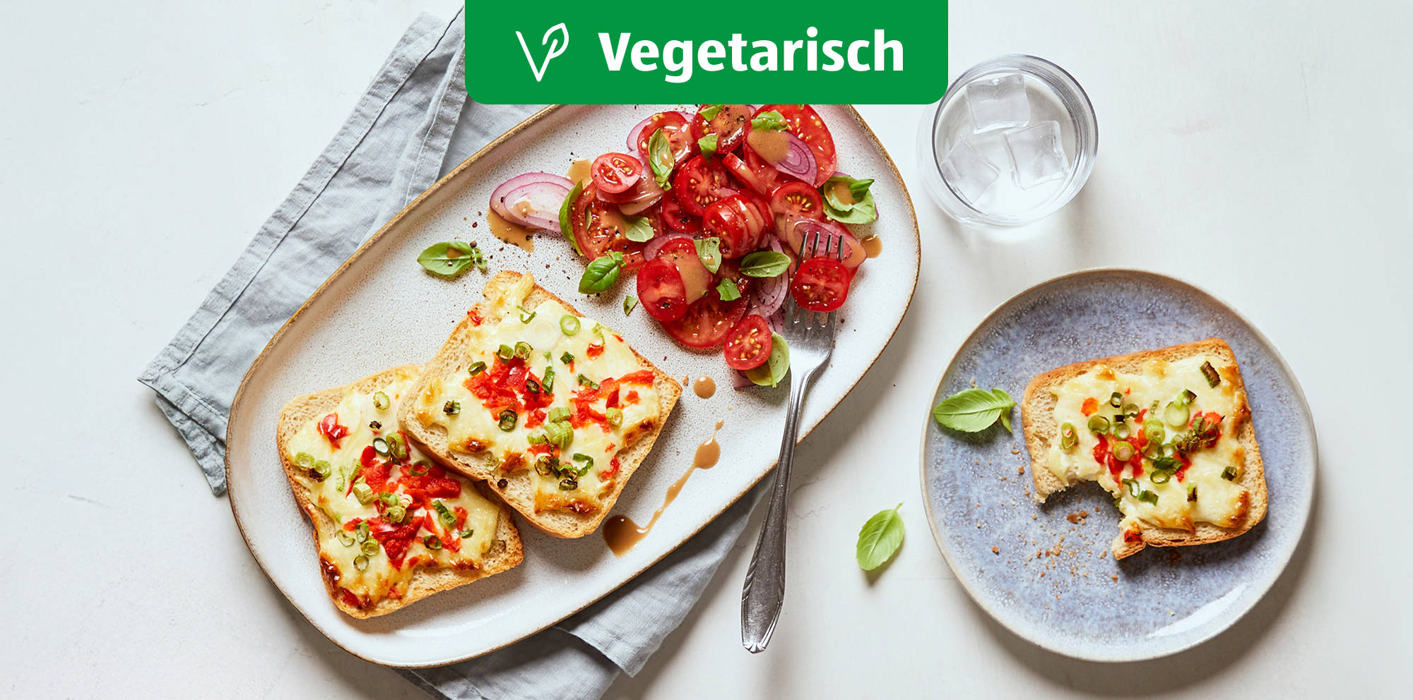 Vegetarischer Flammkuchen-Toast mit Tomatensalat.