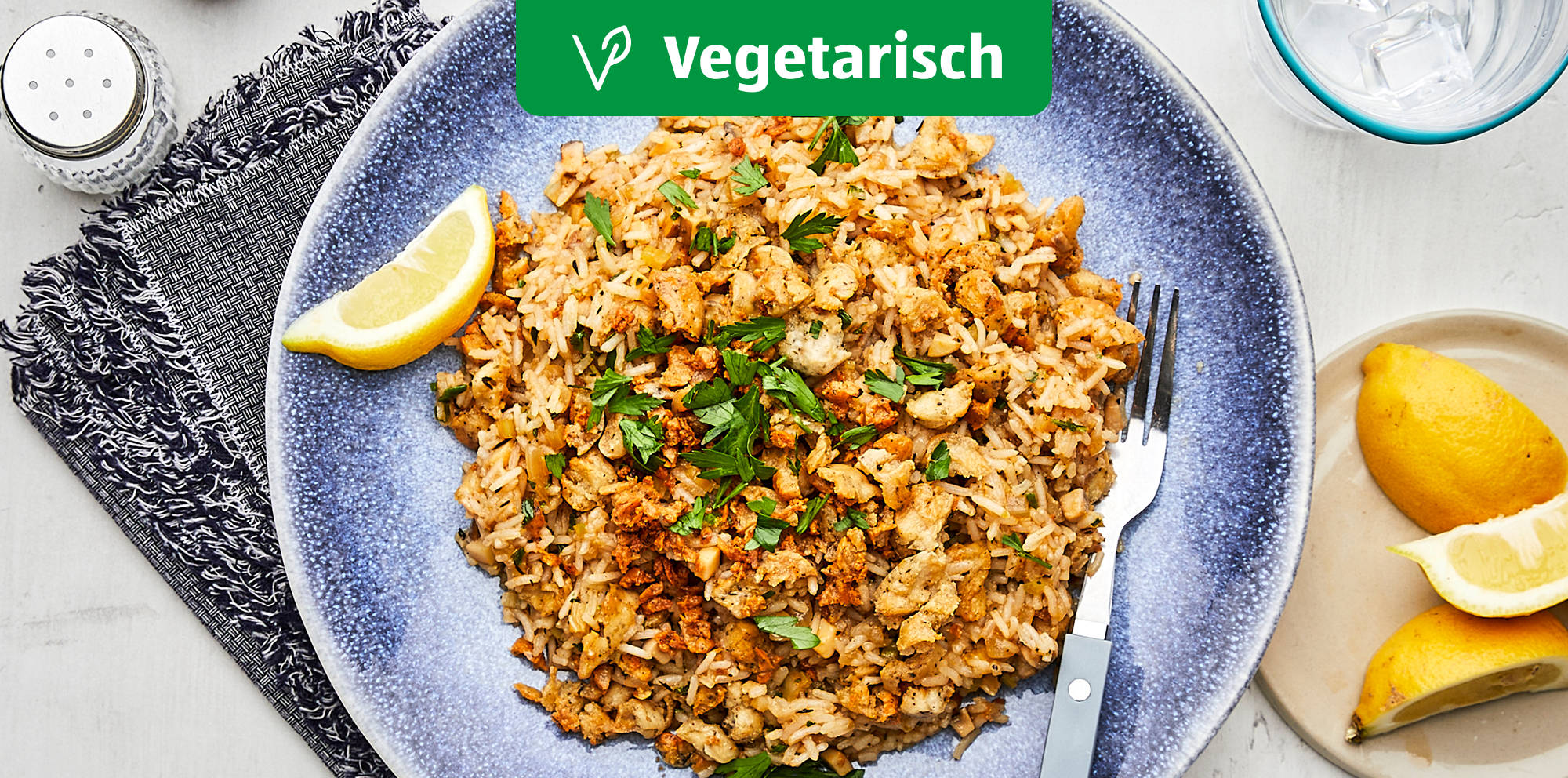 Vegetarisches Reisgericht mit Zitronenspalten.
