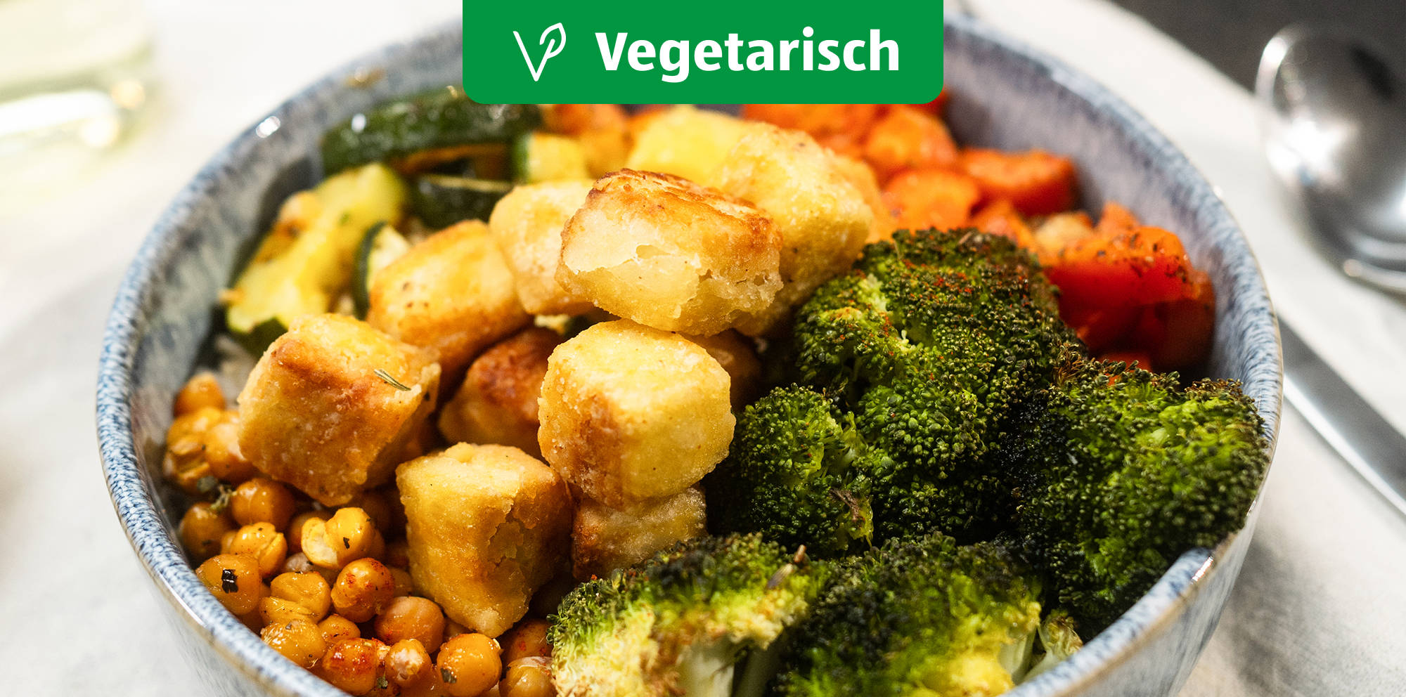 Bunte vegetarische Bowl mit Tofuwürfeln.