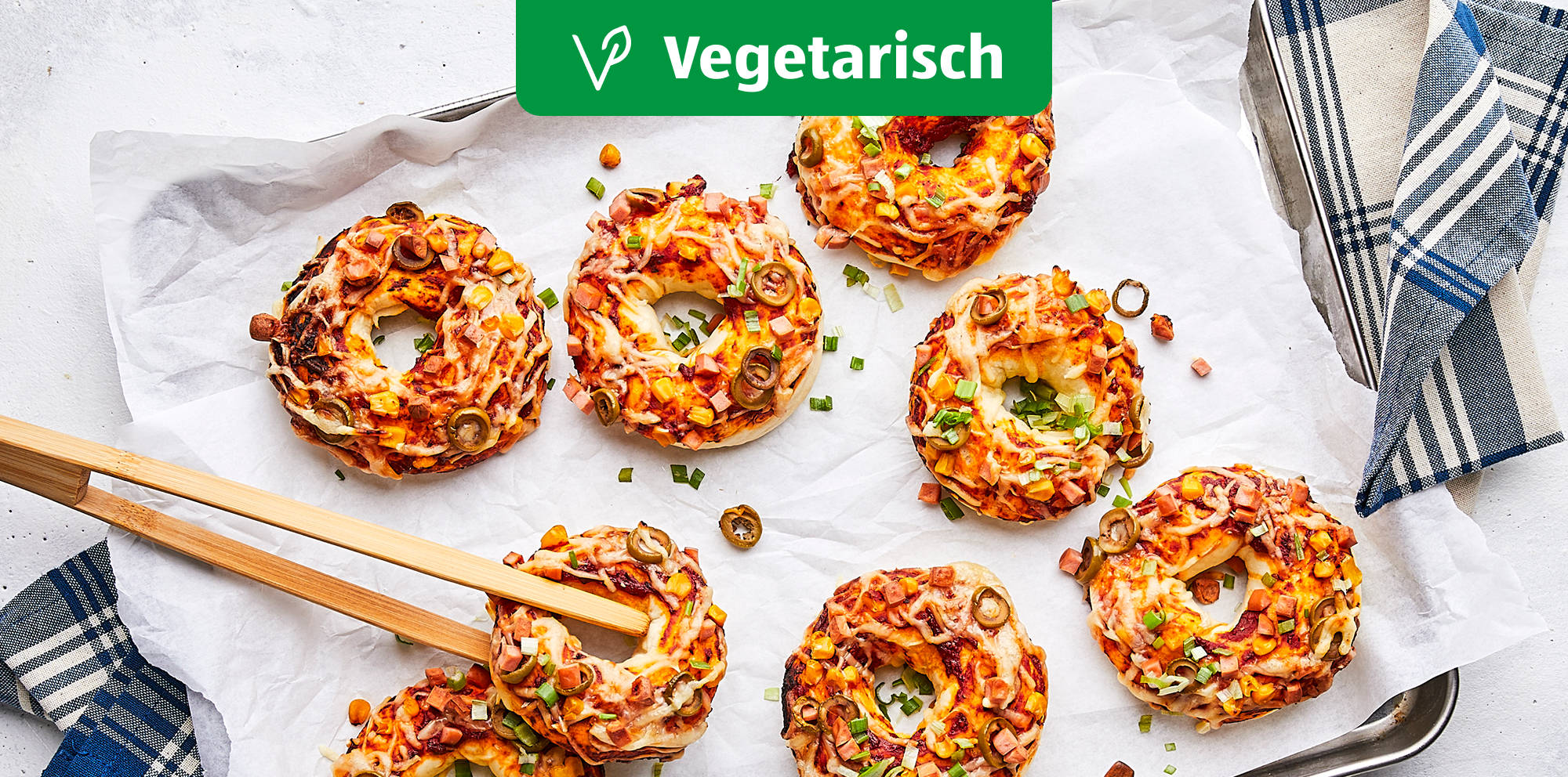 Bunte vegetarische Bagel-Pizzen auf einem Tablett.