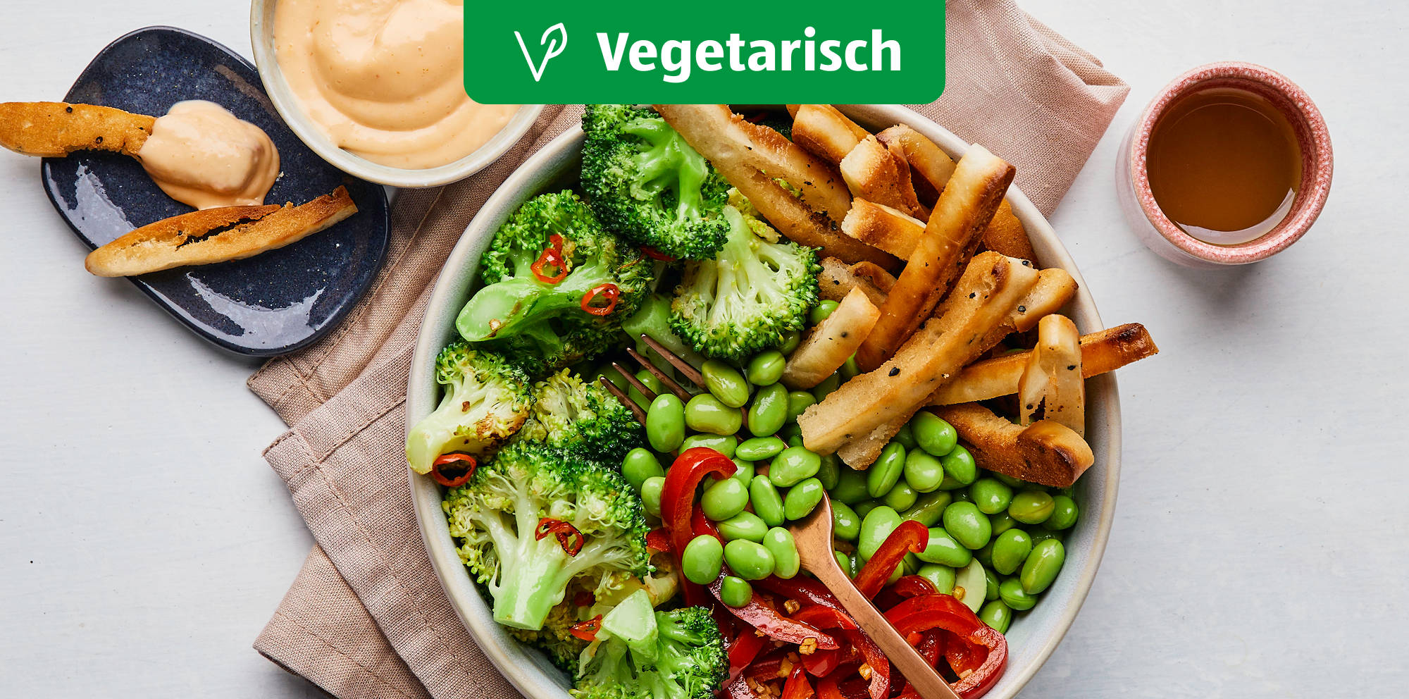 Bunte vegetarische Bowl mit Gemüse und Pommes.