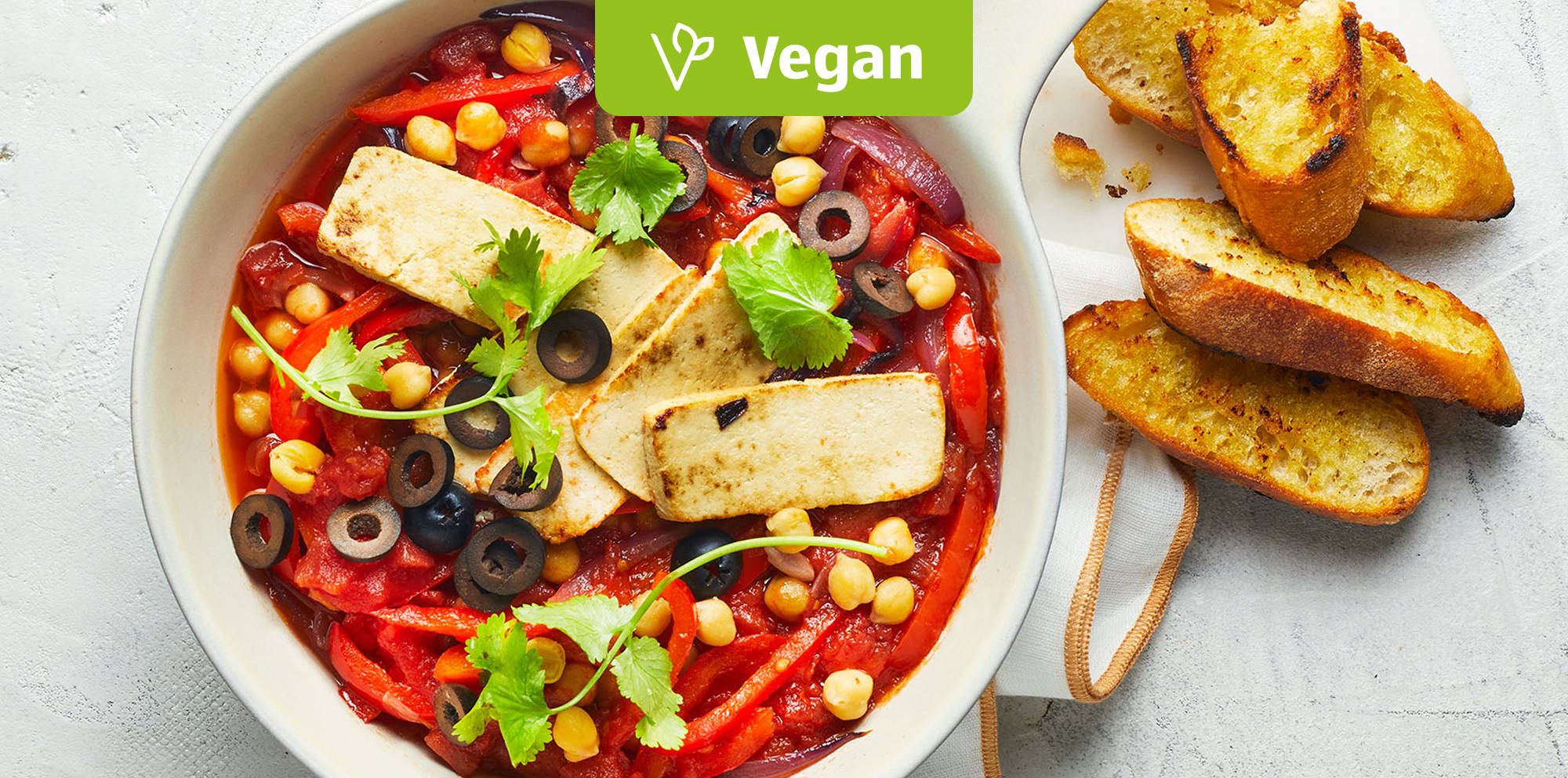 Veganer Eintopf mit Tofu und Brot.