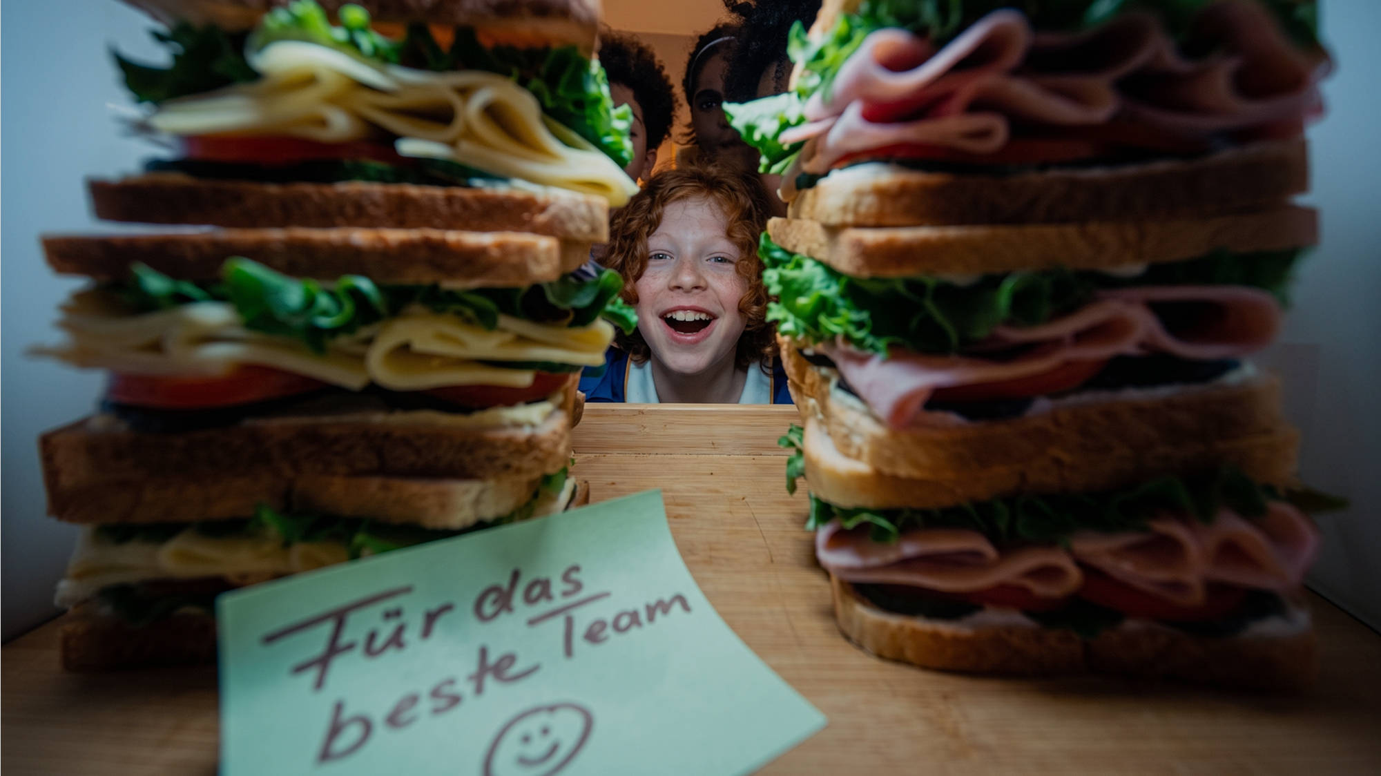 Mehrere belegte Sandwiches mit Käse, Schinken, Salat und Tomaten.