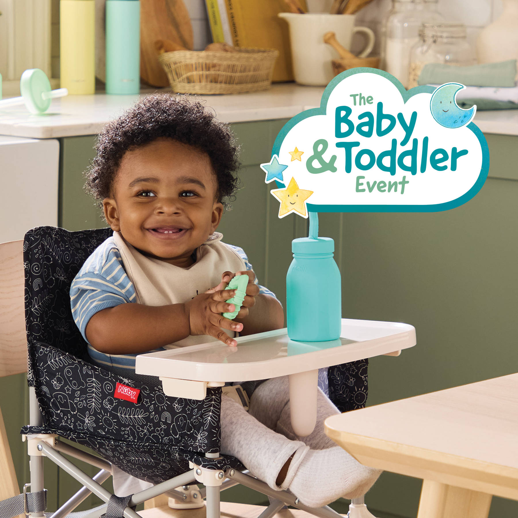 Smiling baby sitting in a high chair holding a blue bottle, with ‘The Baby & Toddler Event’ logo overlay