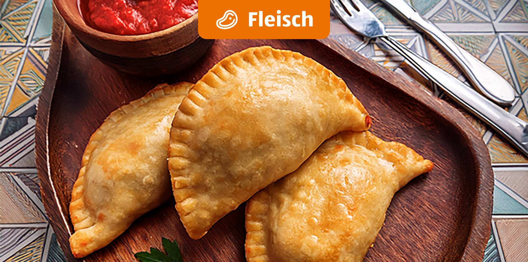 Golden gebackene Empanadas mit Fleischfüllung und Sauce.