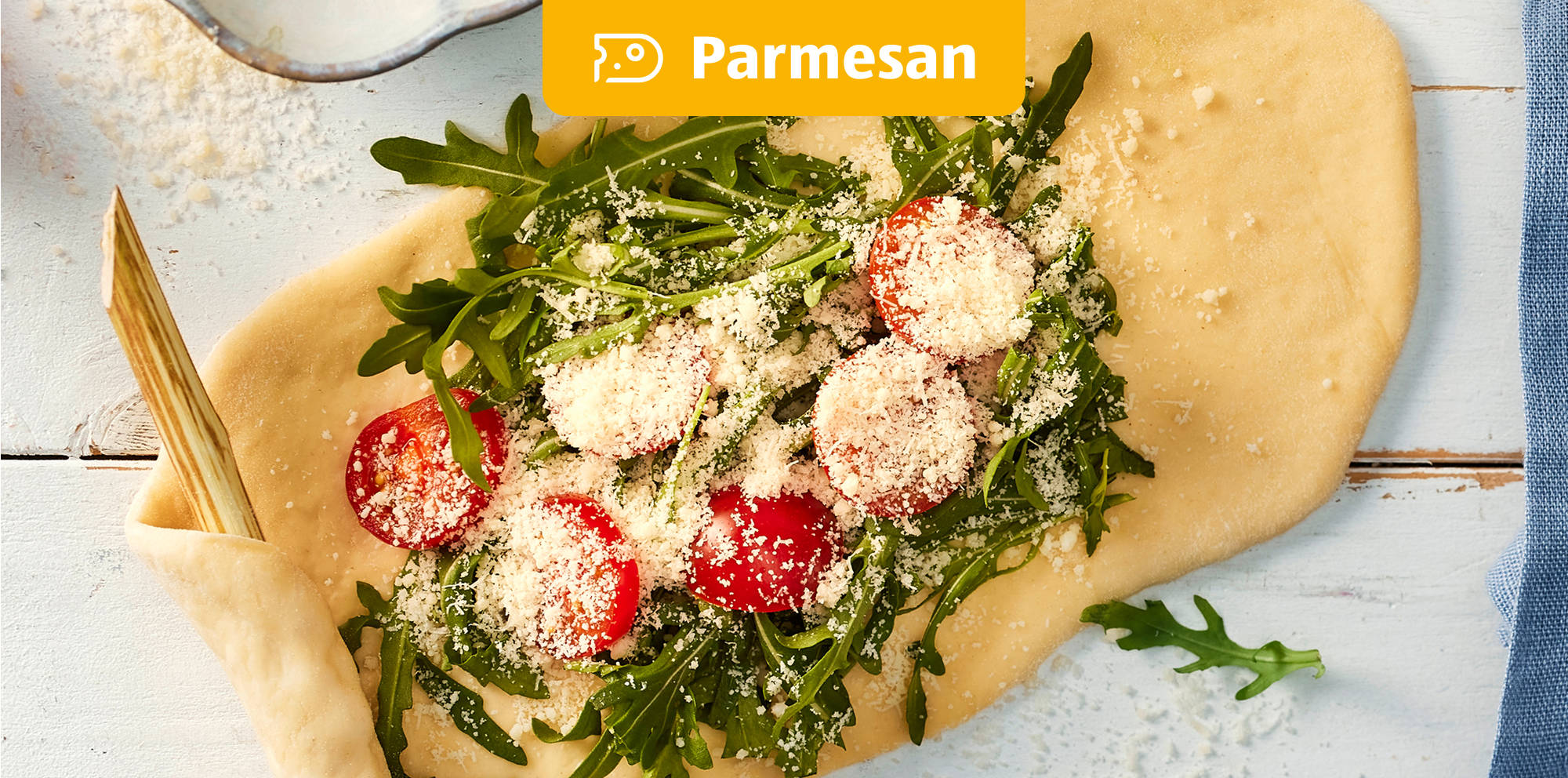 Zubereitung von Fladenbrot mit frischem Rucola und Parmesan.