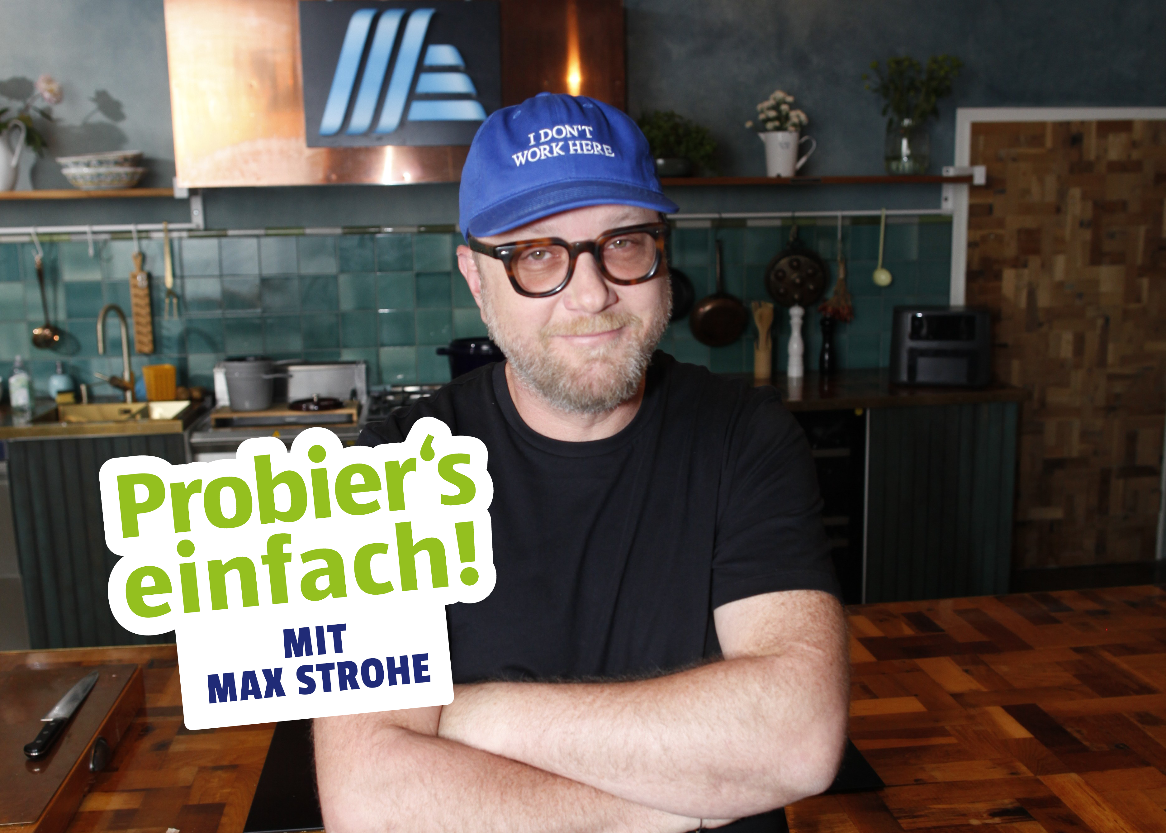 Sternekoch Max Strohe in einer Küche mit dem „Probier’s einfach!“ Badge.