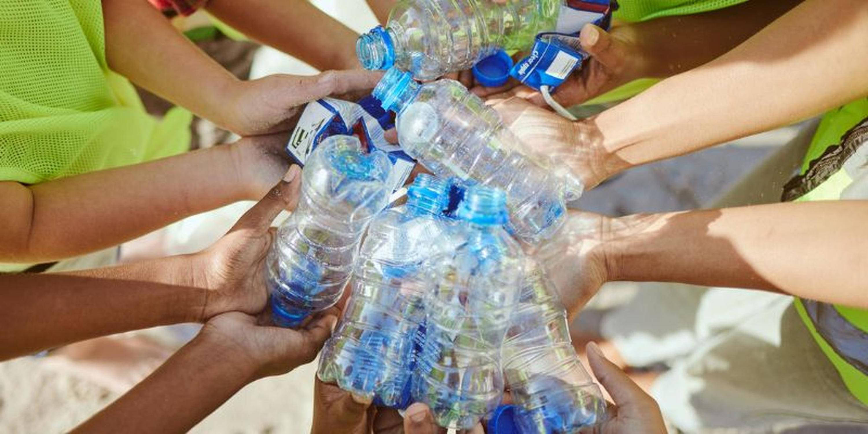 Otroci držijo prazne plasteneke v rokah