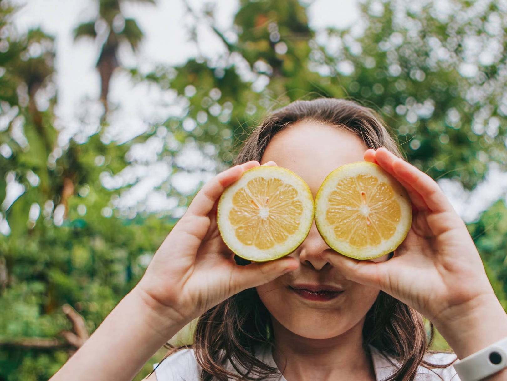 Person hält Zitronenhälften im Garten im Freien.