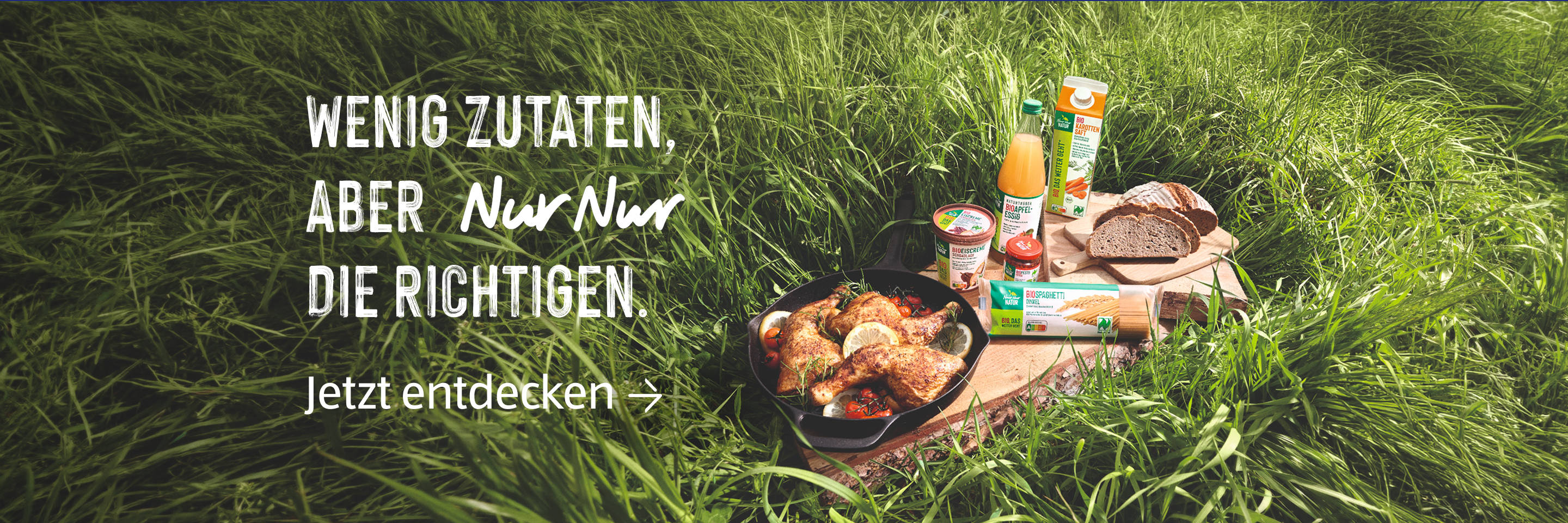 Picknick mit Naturkost in hohem Gras.