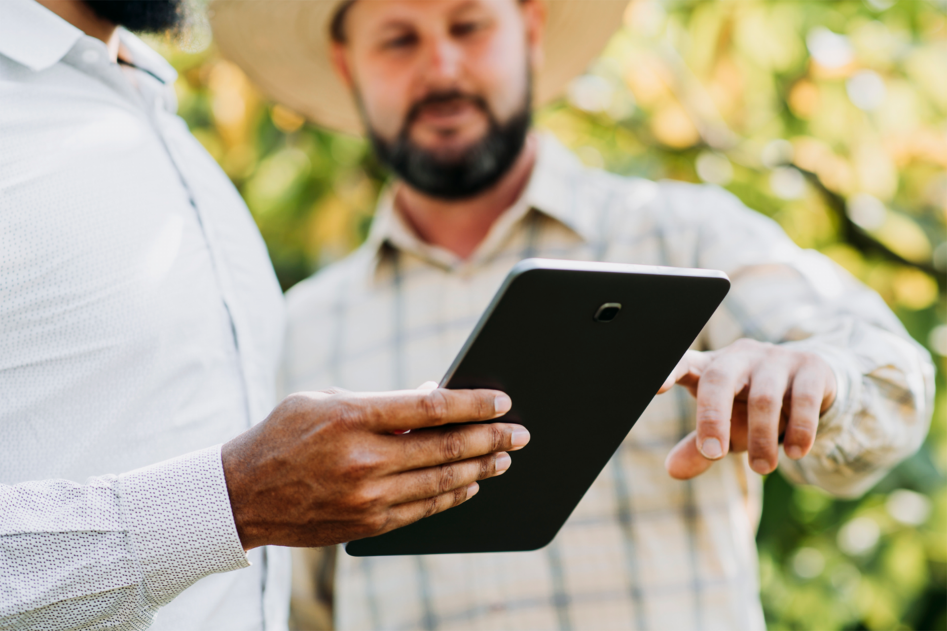 Zwei Personen nutzen Tablet im Freien.