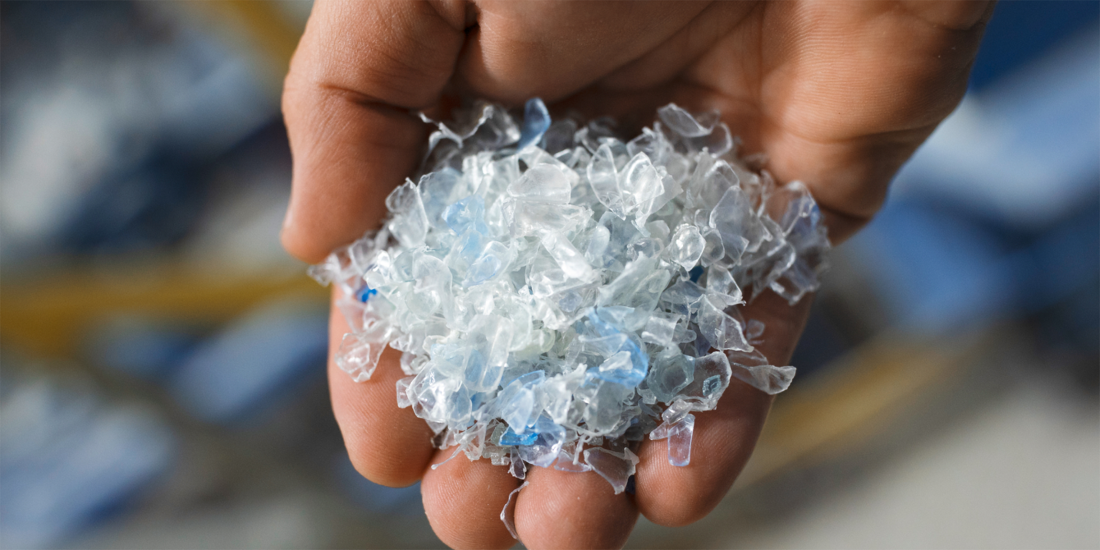 Eine Hand voll Kunststoff-Flakes für neue PET-Flaschen.