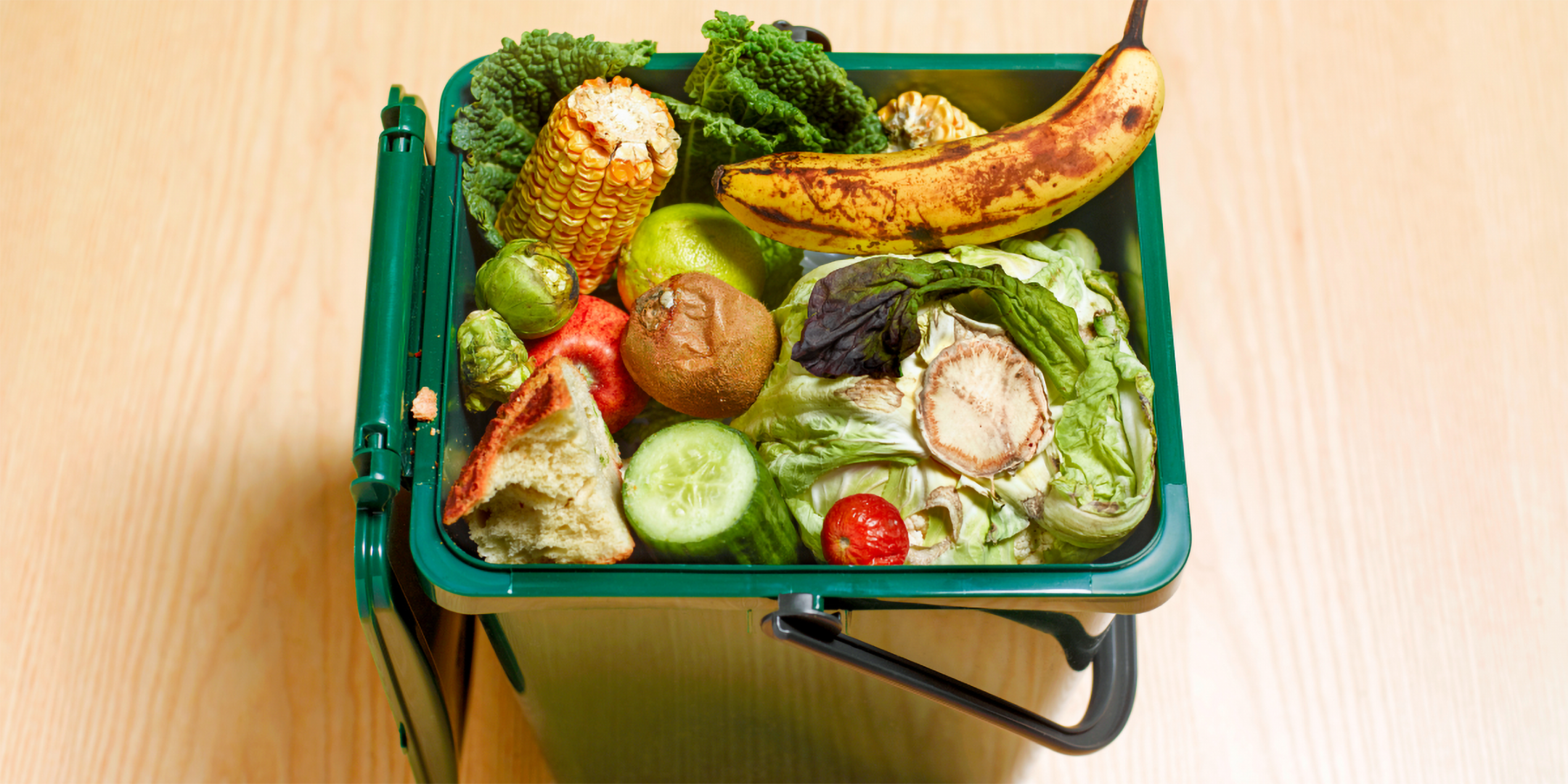 Bio-Abfalleimer mit älterem Obst und Gemüse.