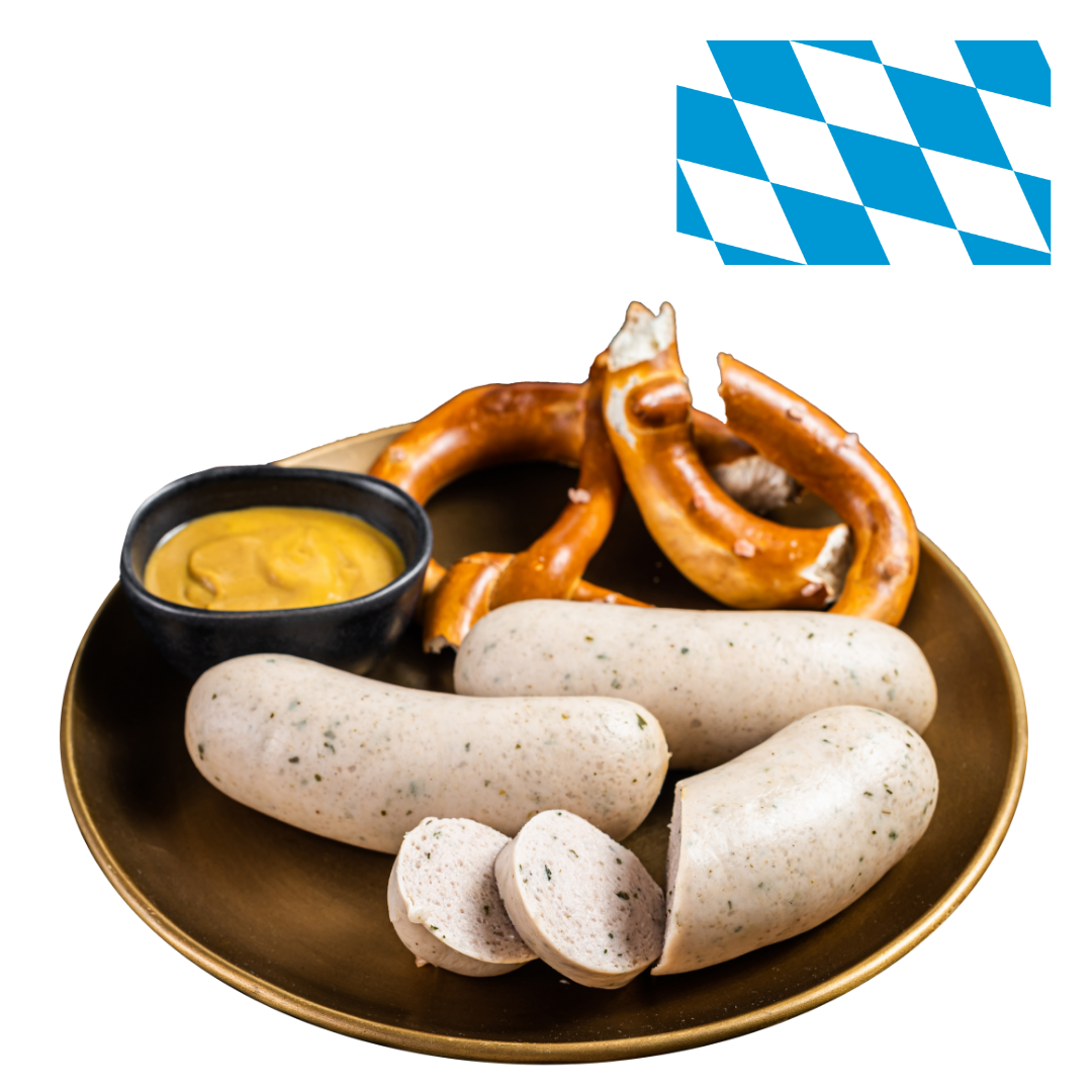 Ein Teller mit Weißwurst, Brezeln und einer Schüssel Senf, darüber ist die bayerische Flagge platziert.