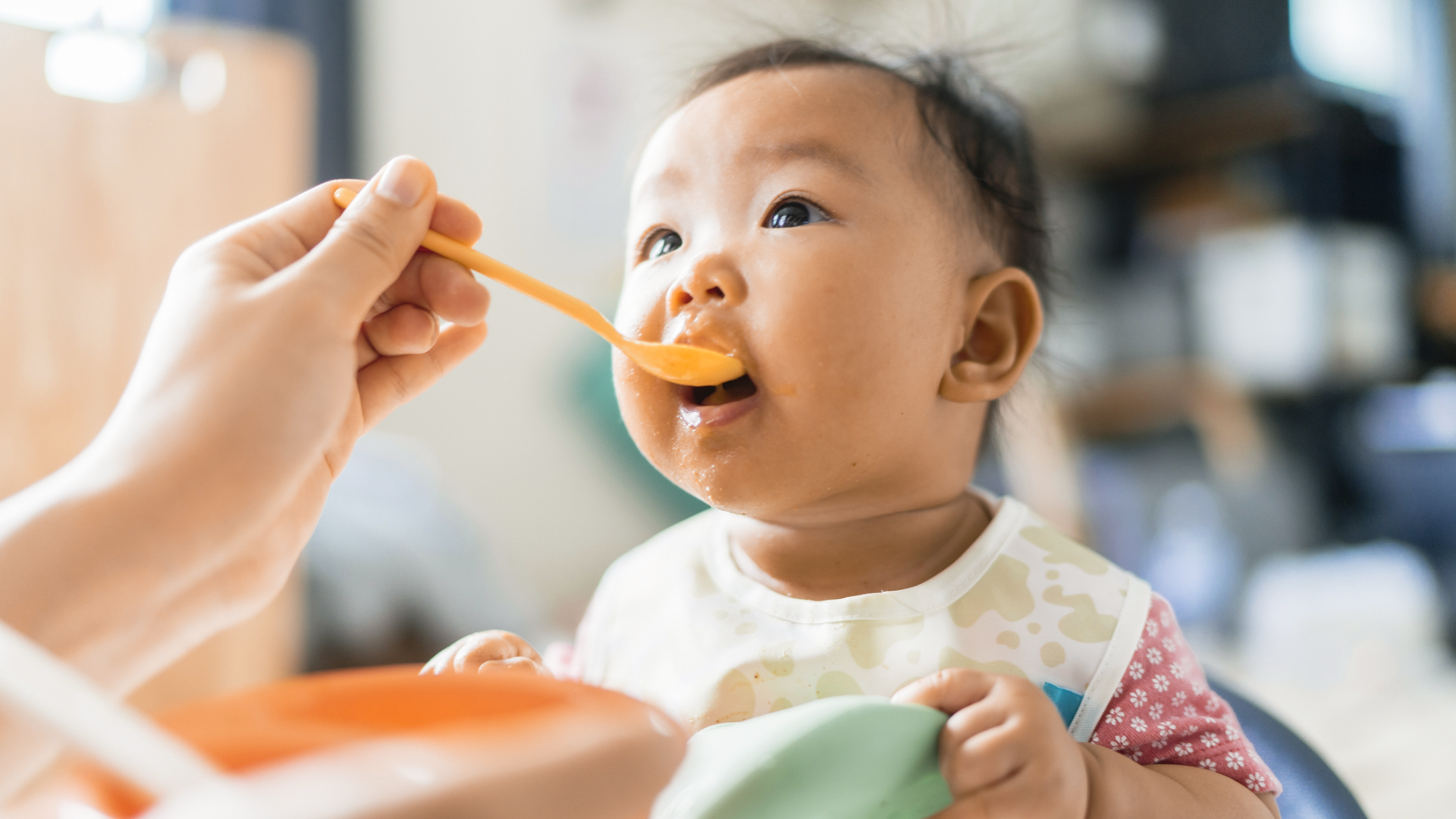 Baby wird mit Löffel gefüttert, Blick nach oben.