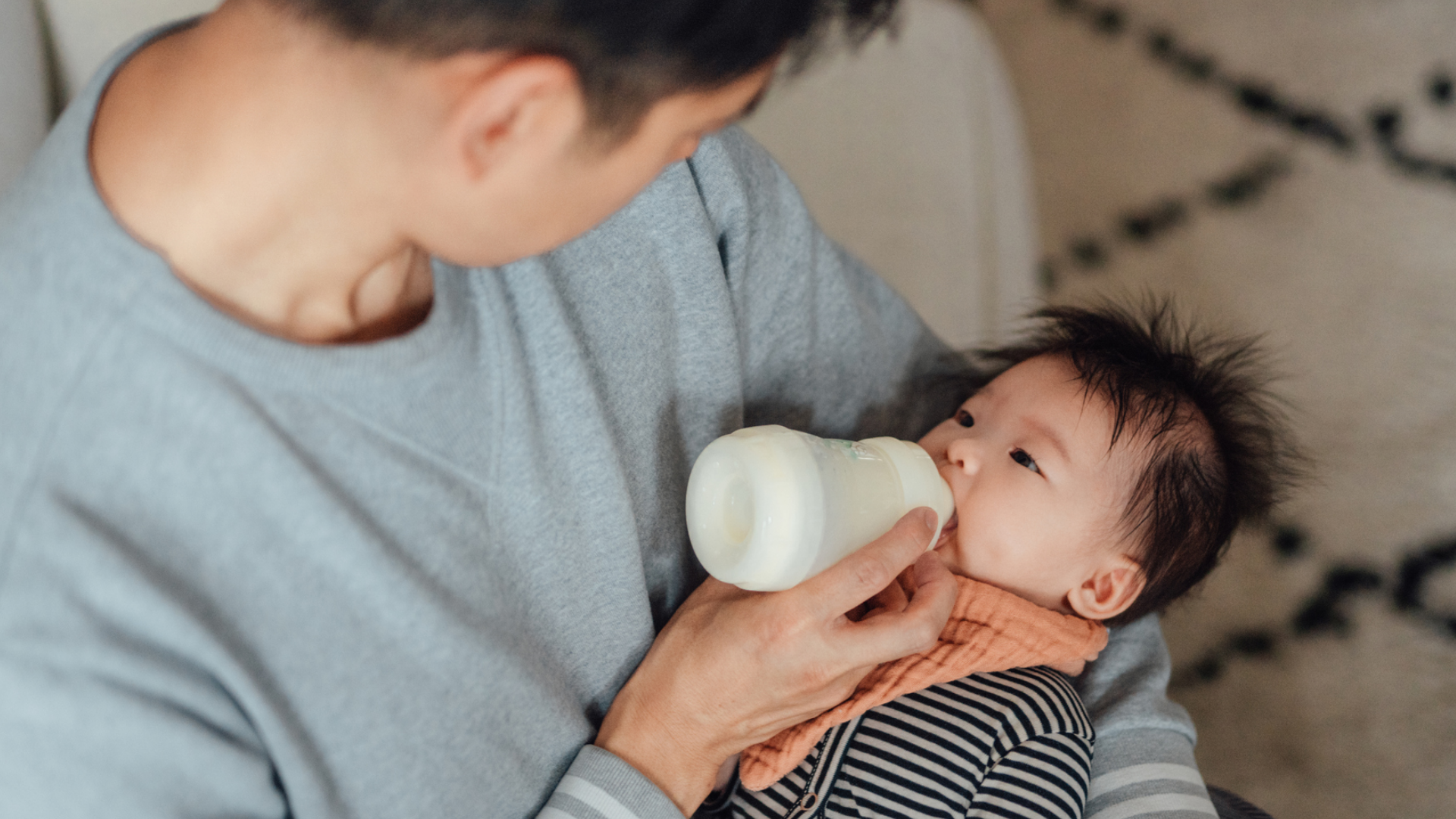 Vater füttert Baby mit Flasche, Nahaufnahme.
