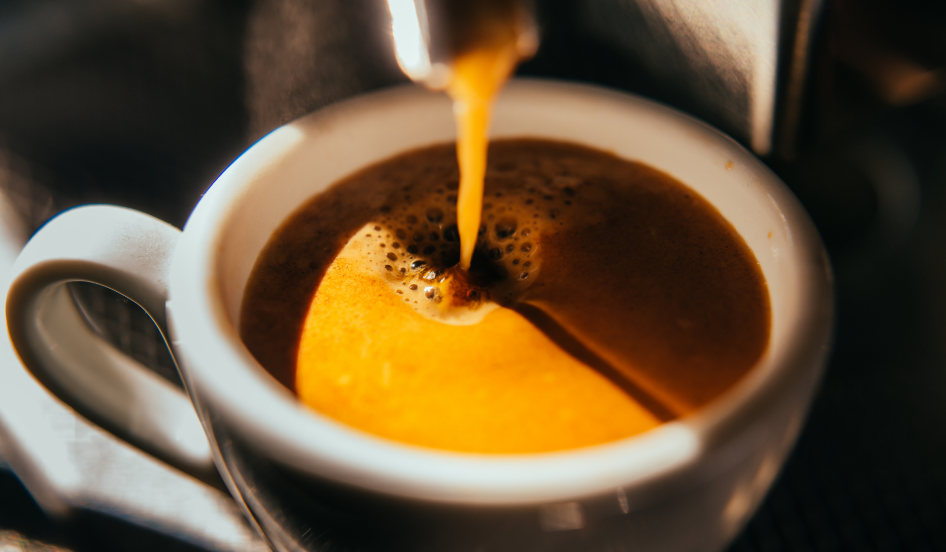 Espresso läuft in eine weiße Tasse.