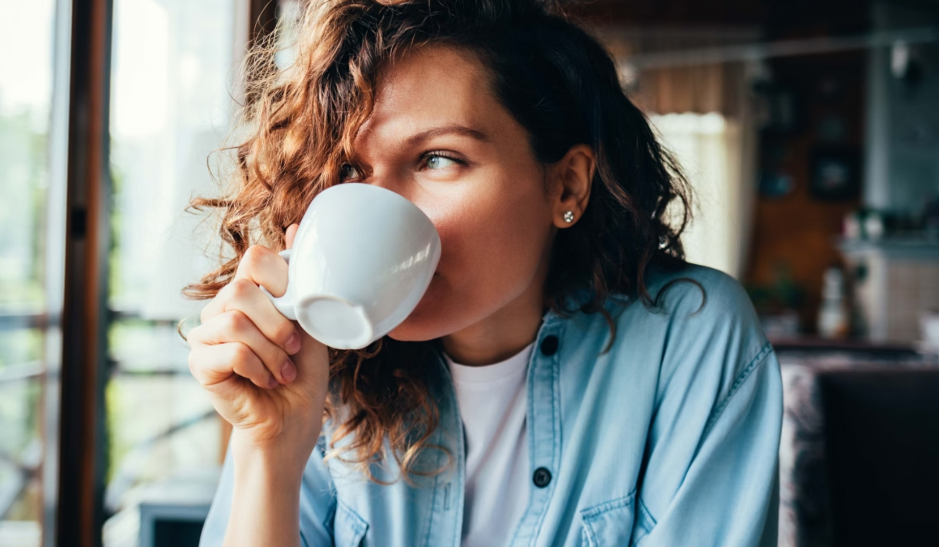 Eine junge Frau genießt ihren Morgenkaffee.