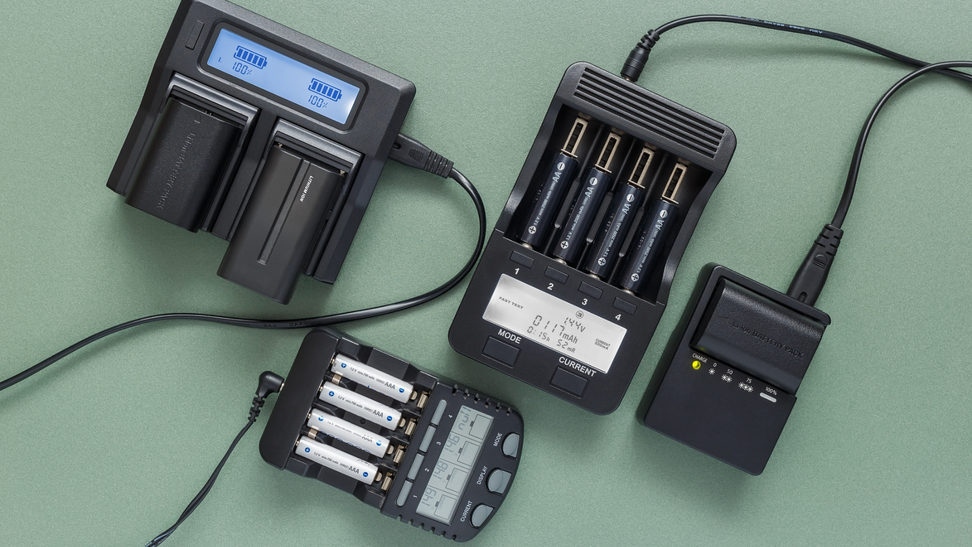 Mehrere Batterieladegeräte mit AA- und AAA-Batterien auf grünem Hintergrund.