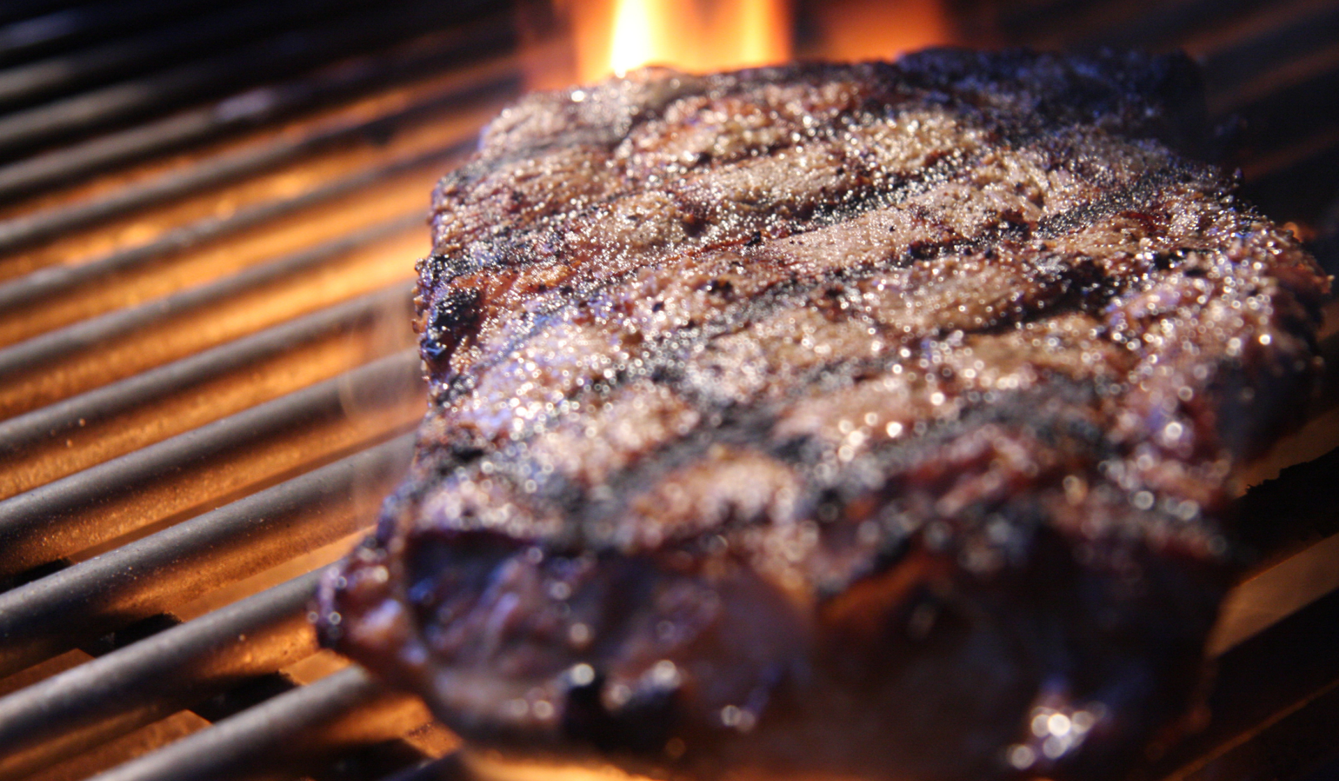 Ein saftiges Steak brutzelt auf einem heißen Grill.